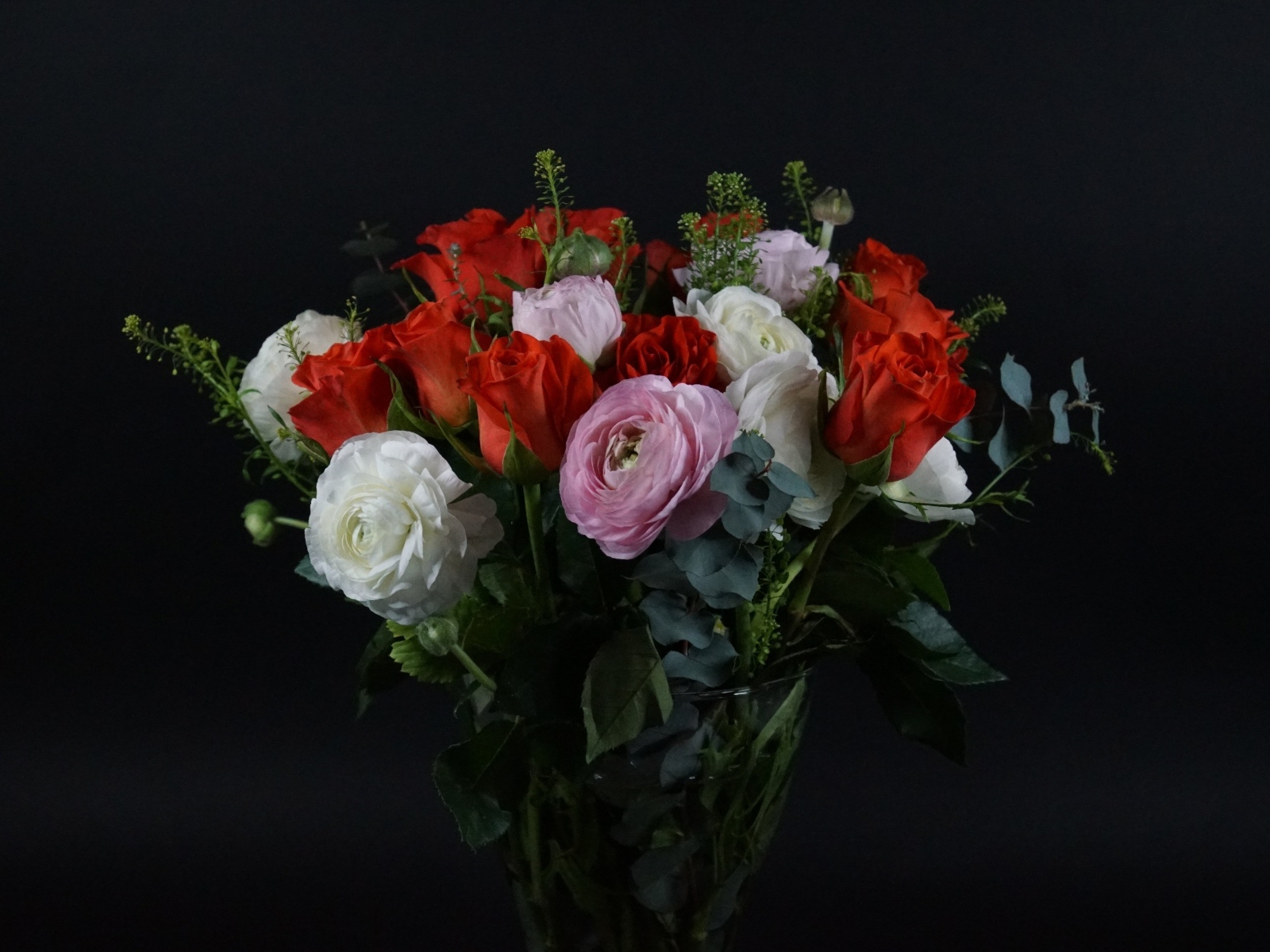 Красивый букет с цветами лютика и красной розы на черном фоне