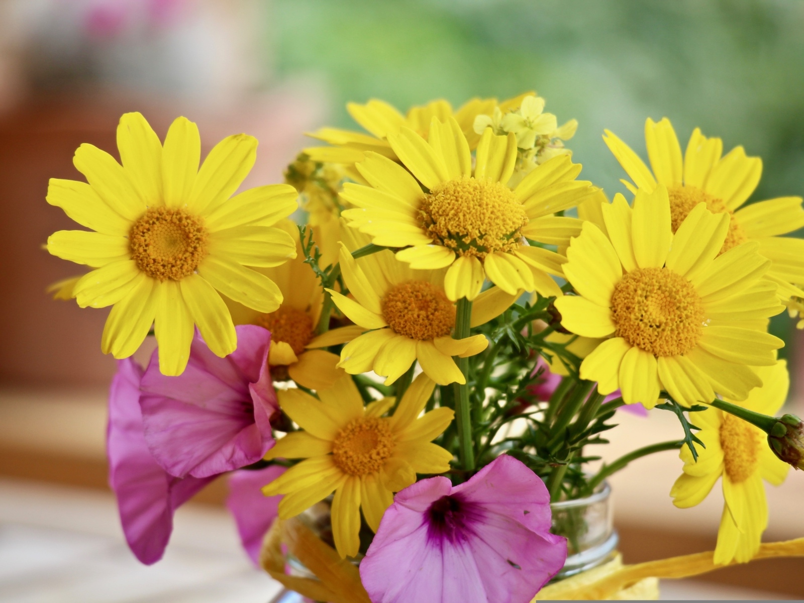 Букет желтых и розовых цветов в вазе на столе