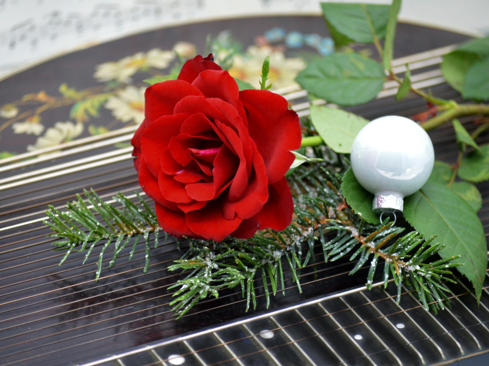 Красная роза с шариком и еловой веткой