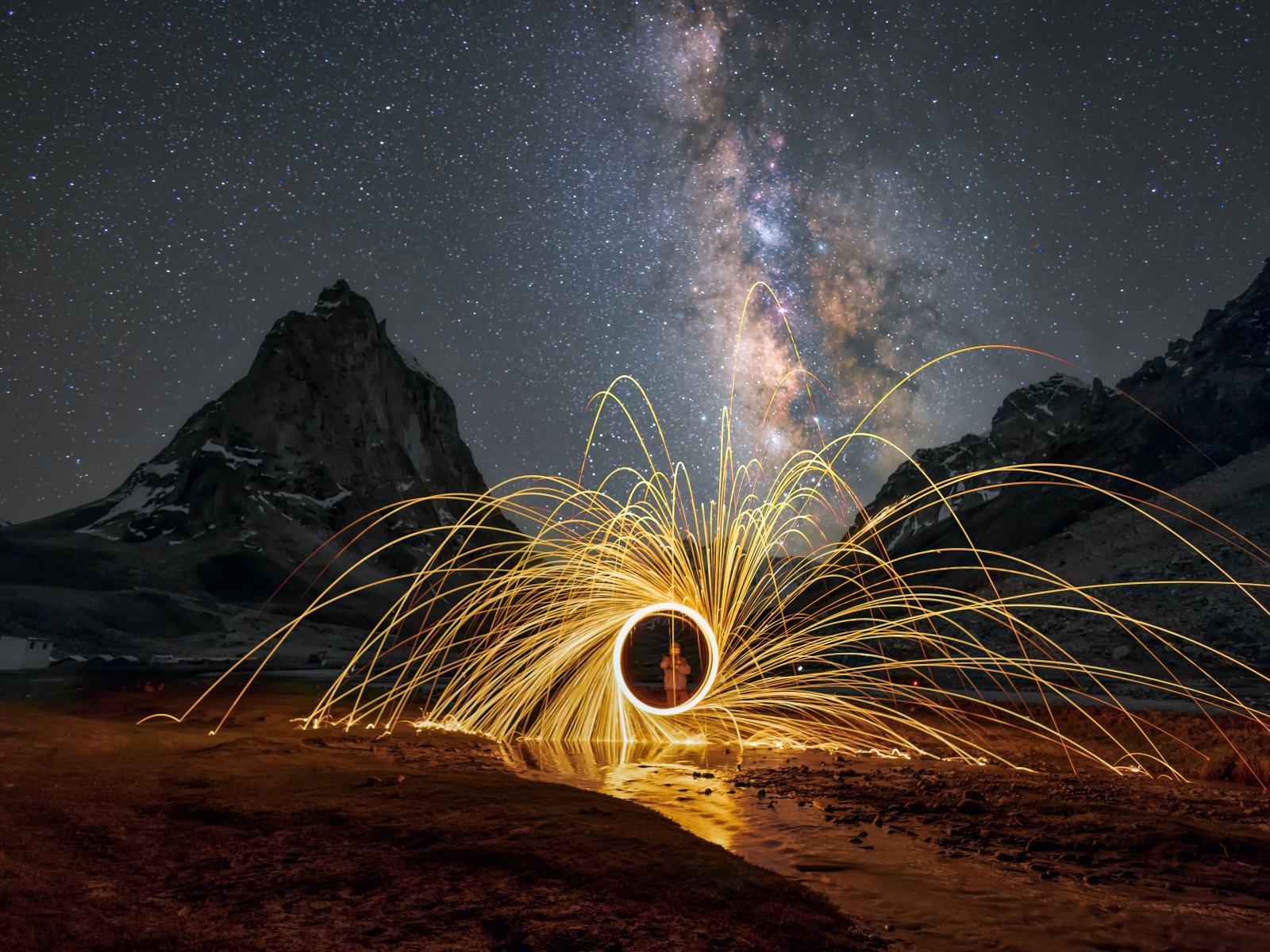 Огненное шоу под ночным красивым небом в горах