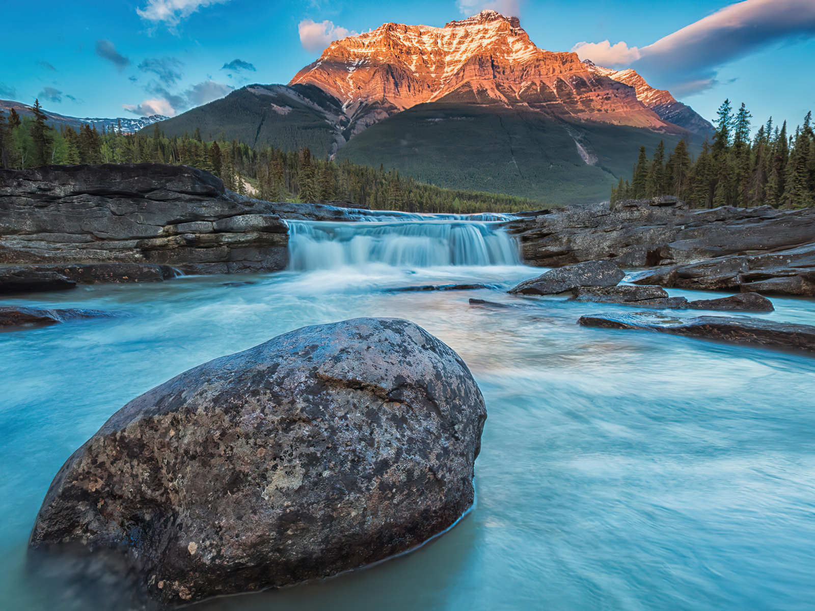 Большой камень лежит в реке у горы