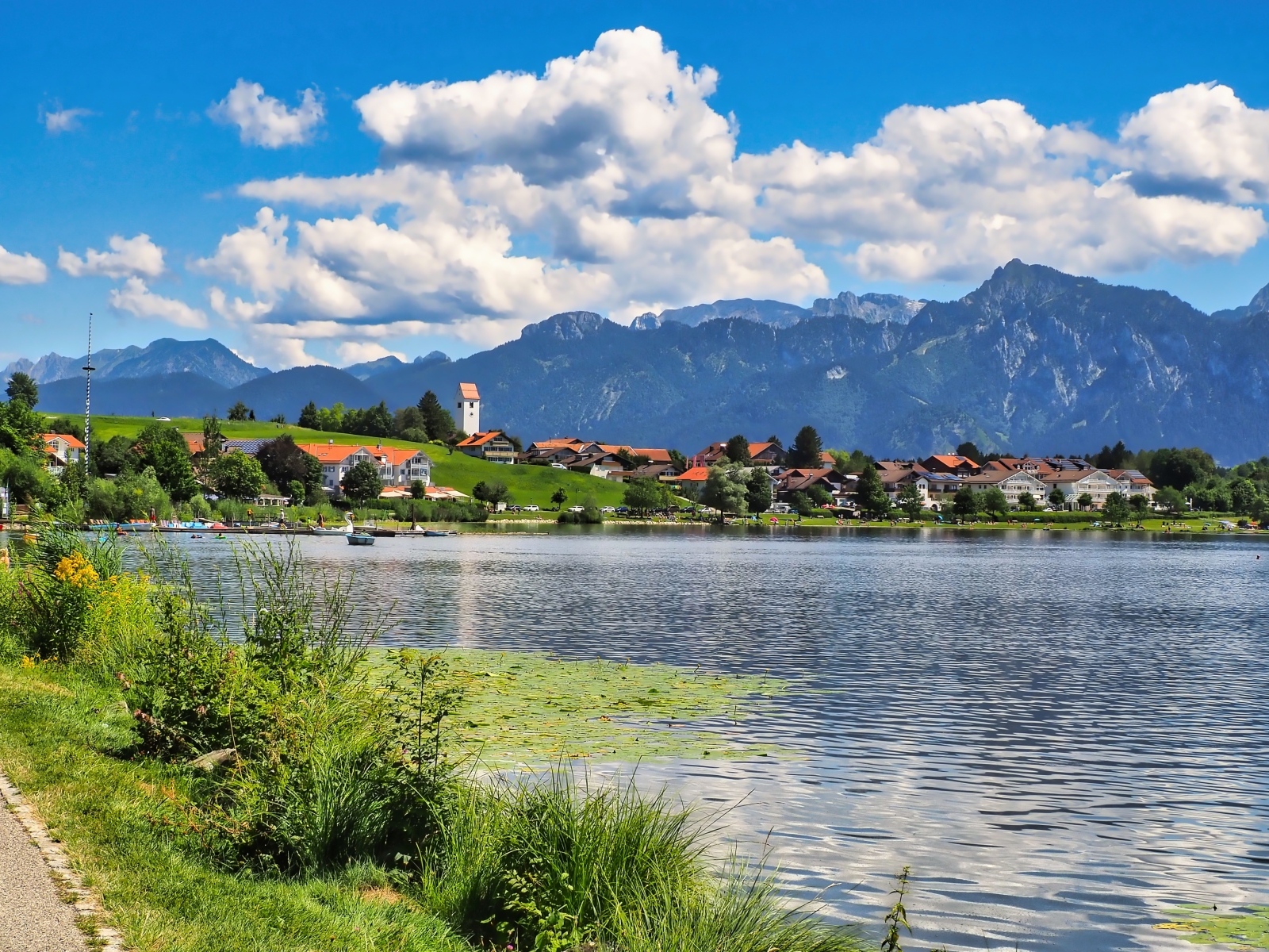 Красивый вид на озеро и горы под голубым небом с белыми облаками