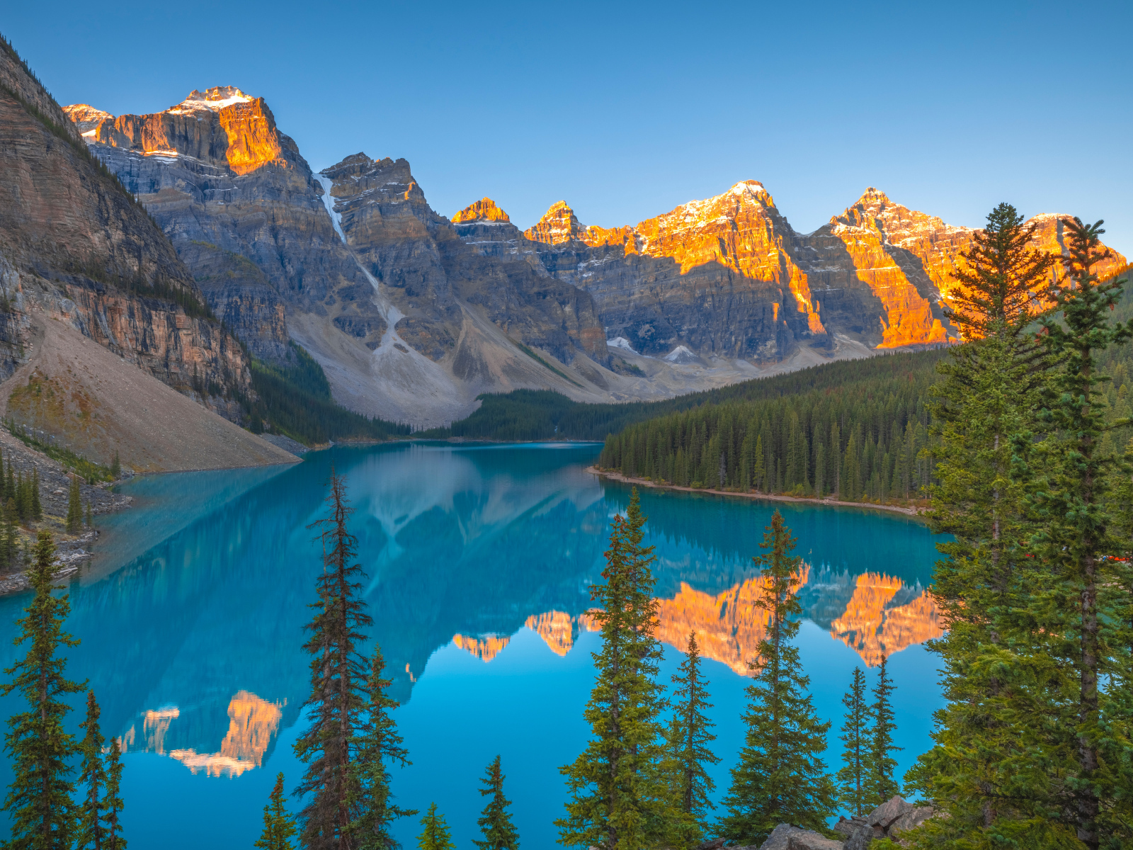 Солнце над вершинами гор у голубого озера