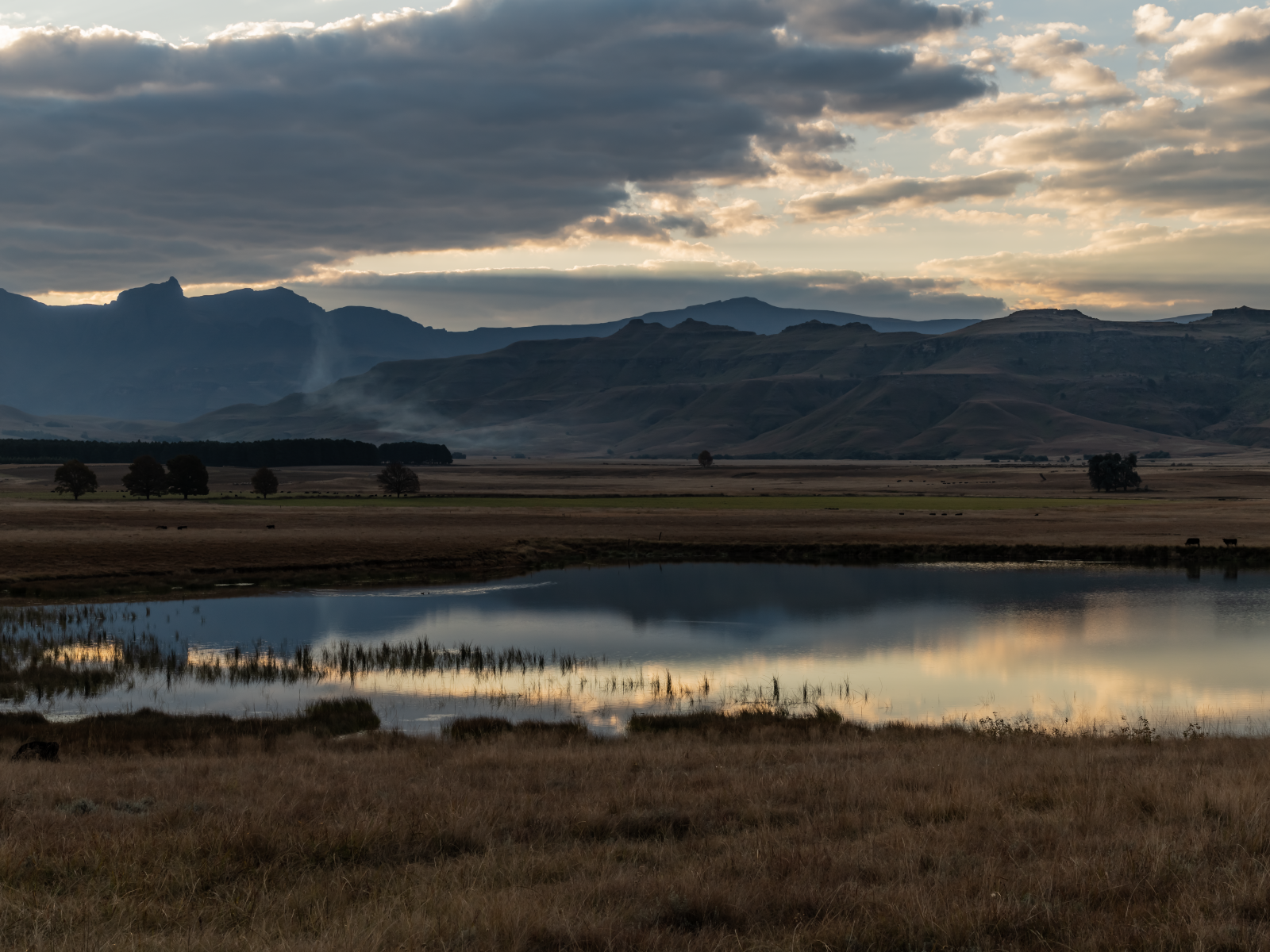 Грозовые облака отражаются в воде озера в горах 