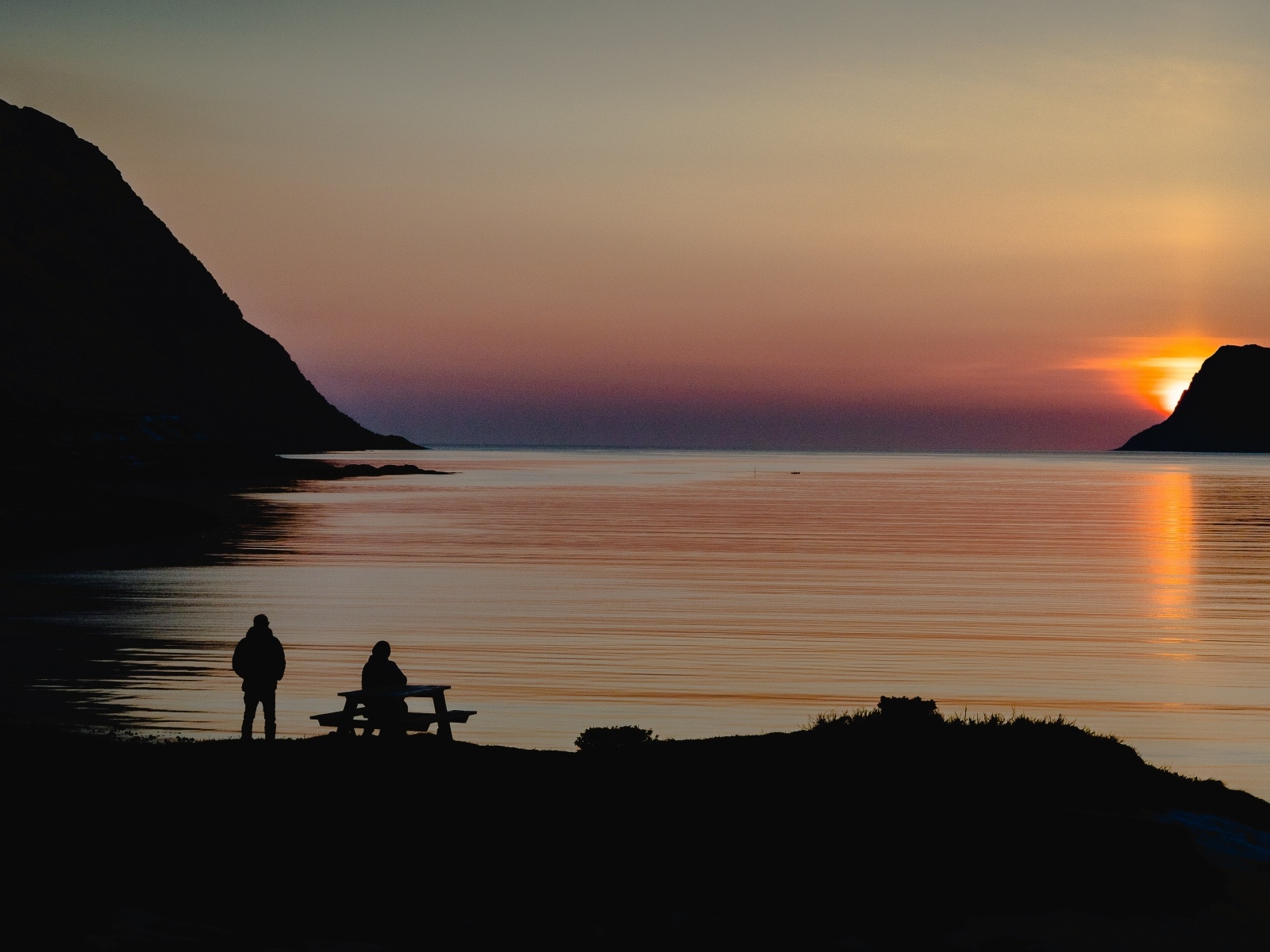 Солнце скрывается за горой в заливе
