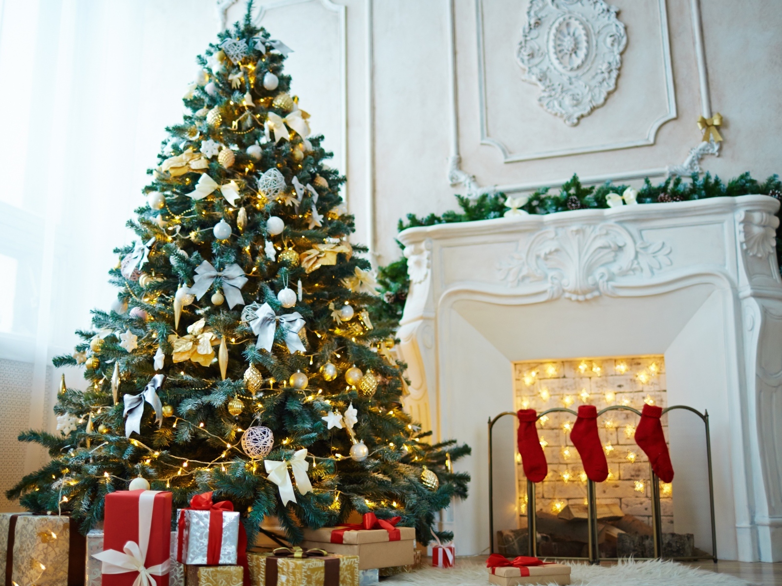 Красивая наряженная ель в комнате с камином