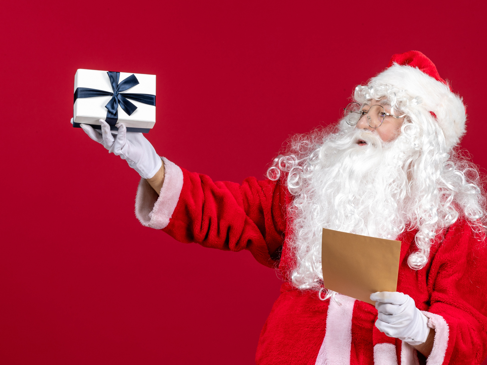 Санта Клаус с письмом на красном фоне