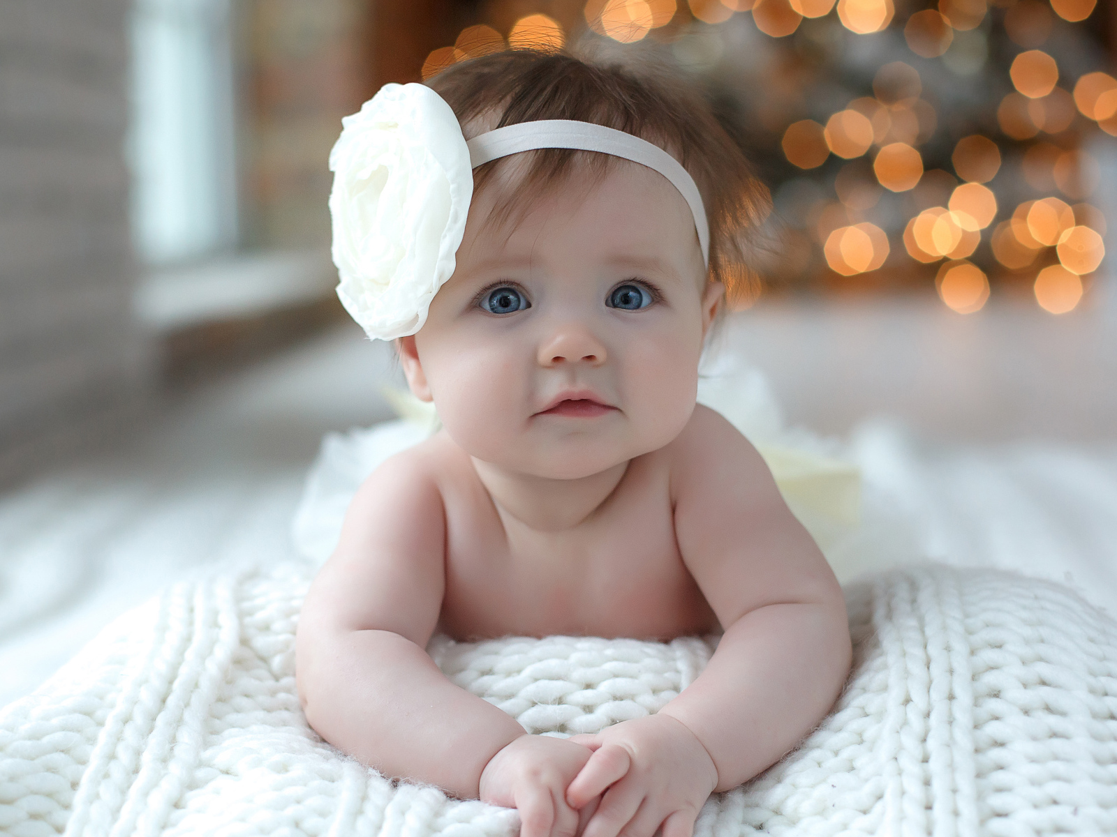 Красивая маленькая девочка с белым цветком на голове