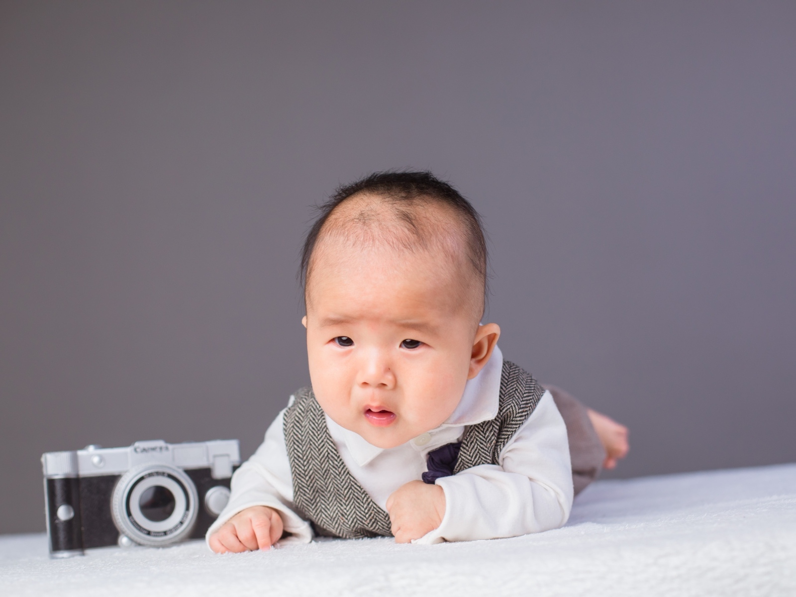 Маленький мальчик в костюме с фотоаппаратом