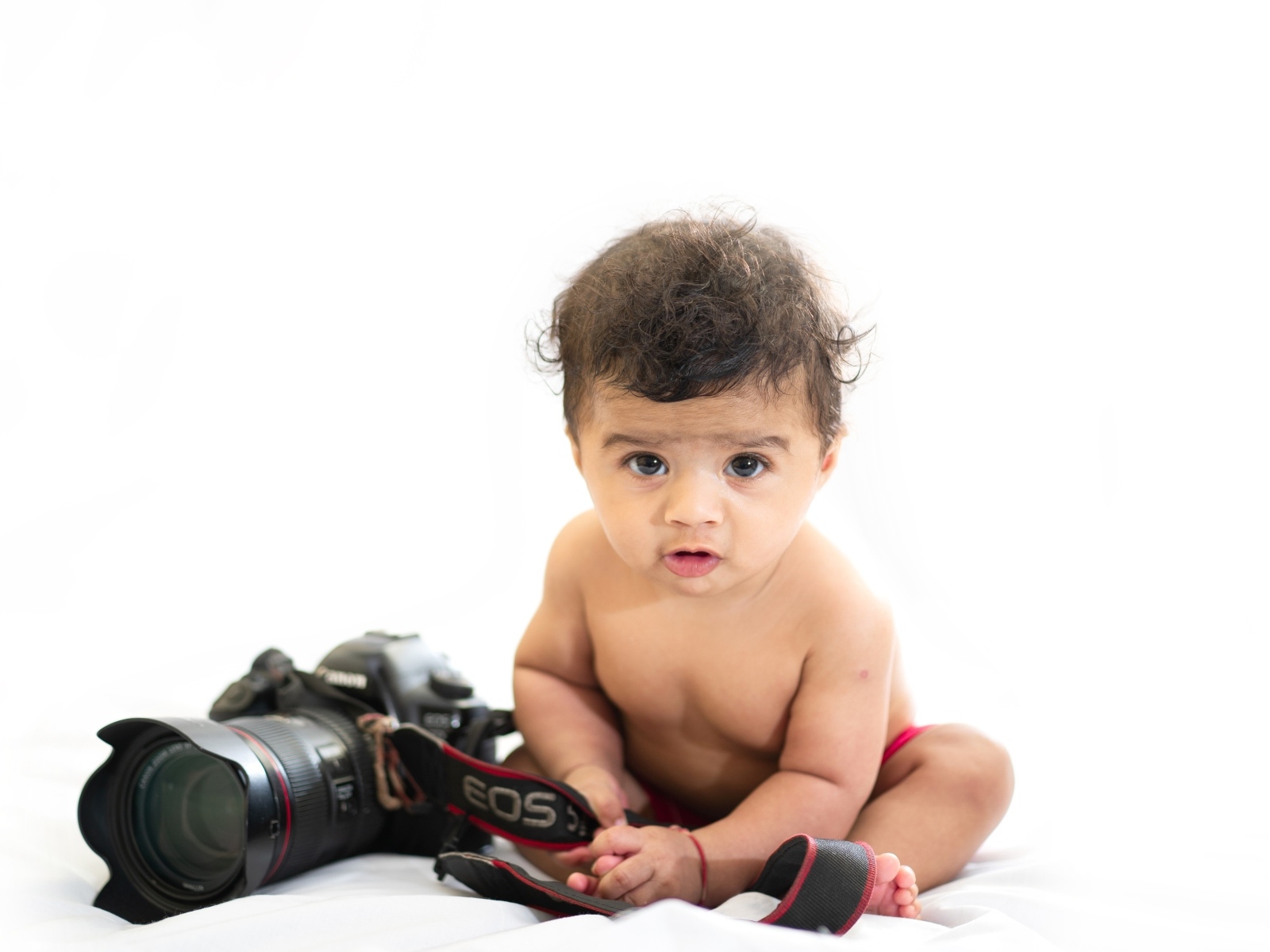 Маленький мальчик с фотоаппаратом на белом фоне