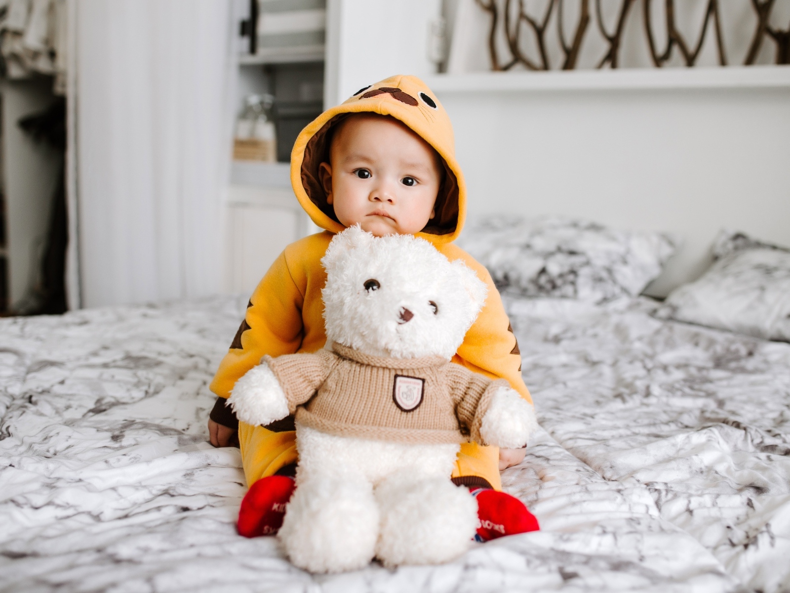 Маленький ребенок с игрушкой на кровати 