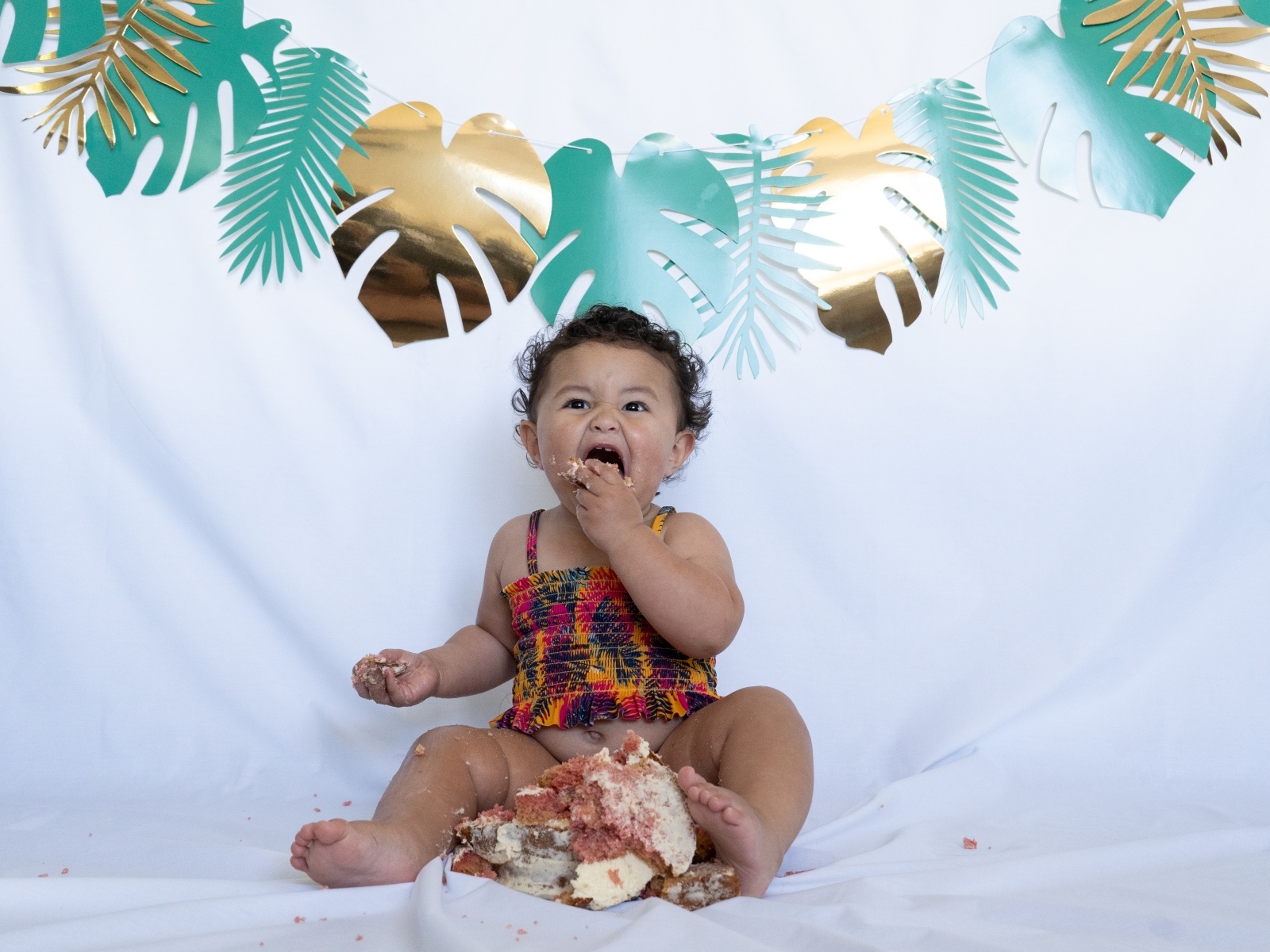 Маленькая девочка ест торт на белом фоне