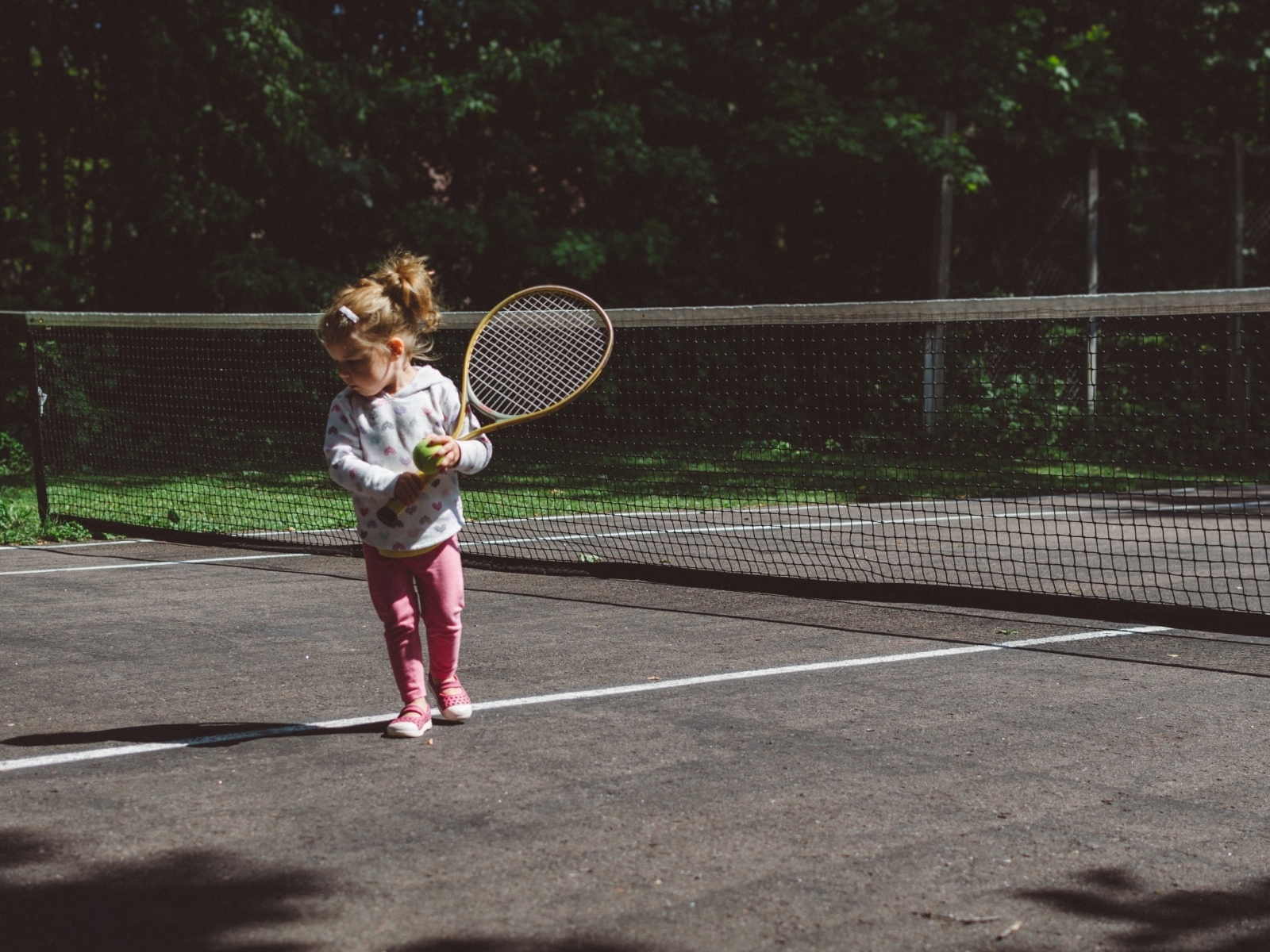 Маленькая девочка с ракеткой на поле