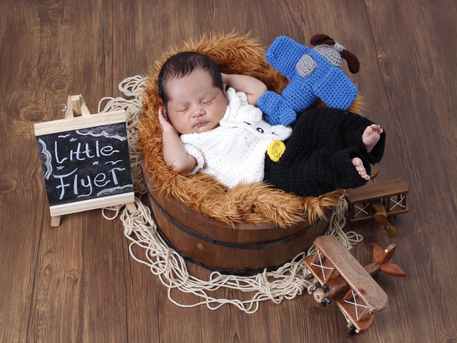 Маленький новорожденный малыш спит в бочке 