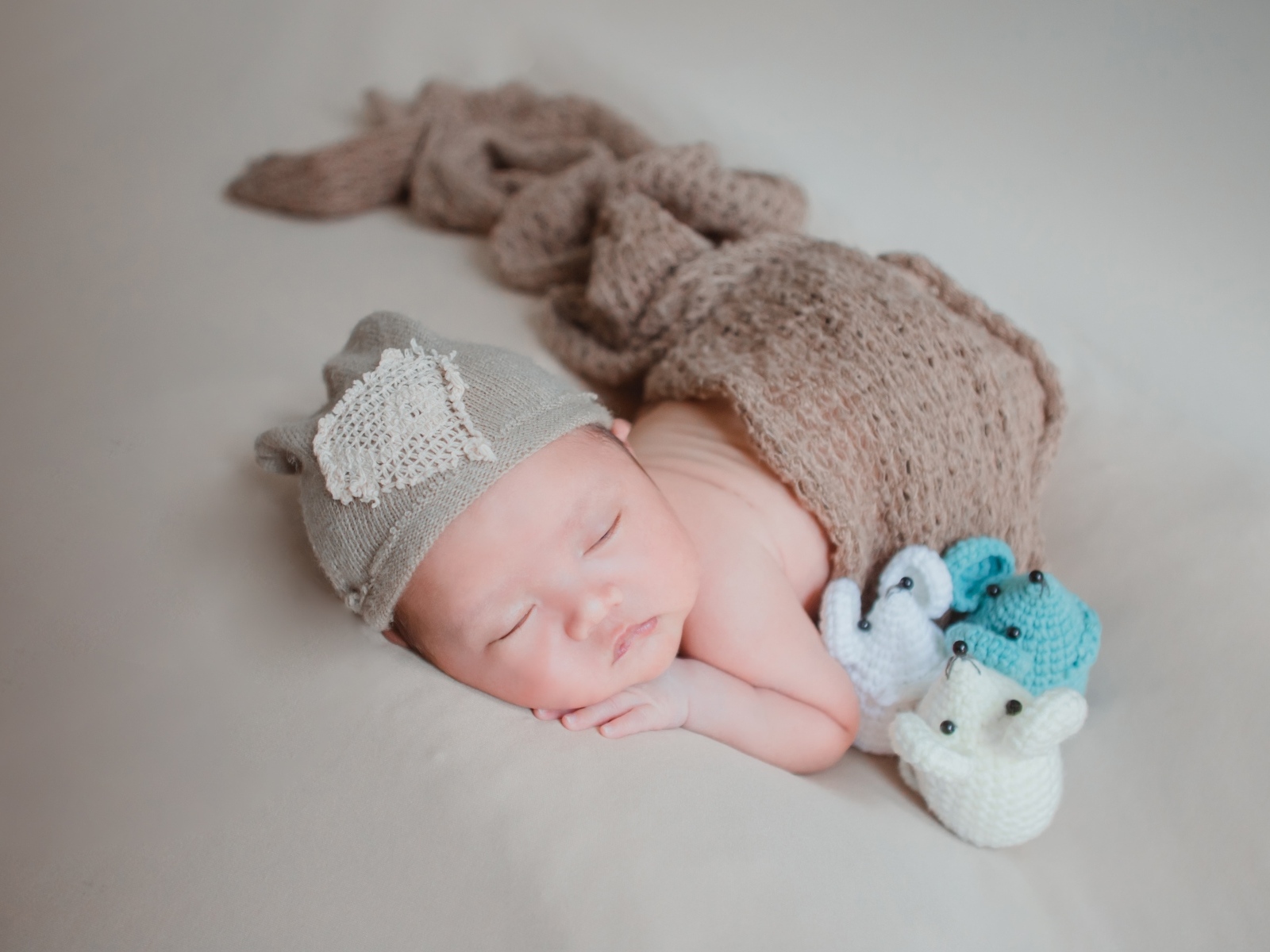 Новорожденный малыш спит на сером покрывале