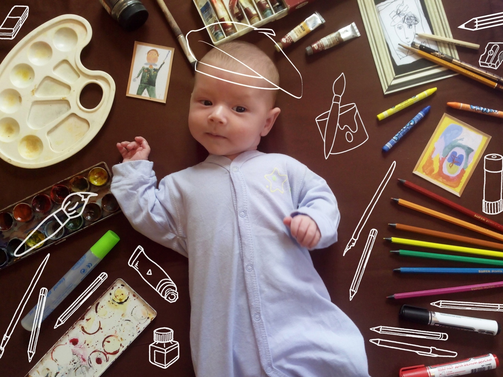 Новорожденный ребенок с канцелярскими предметами