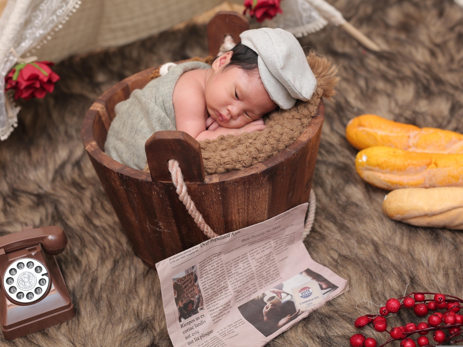 Новорожденный маленький мальчик в деревянном ведре на фотосессии 