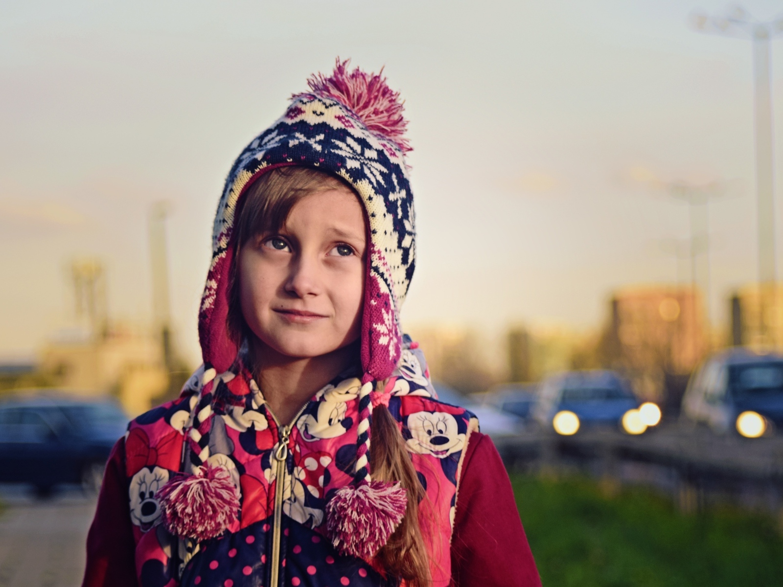 Грустная девочка в теплой шапке на улице