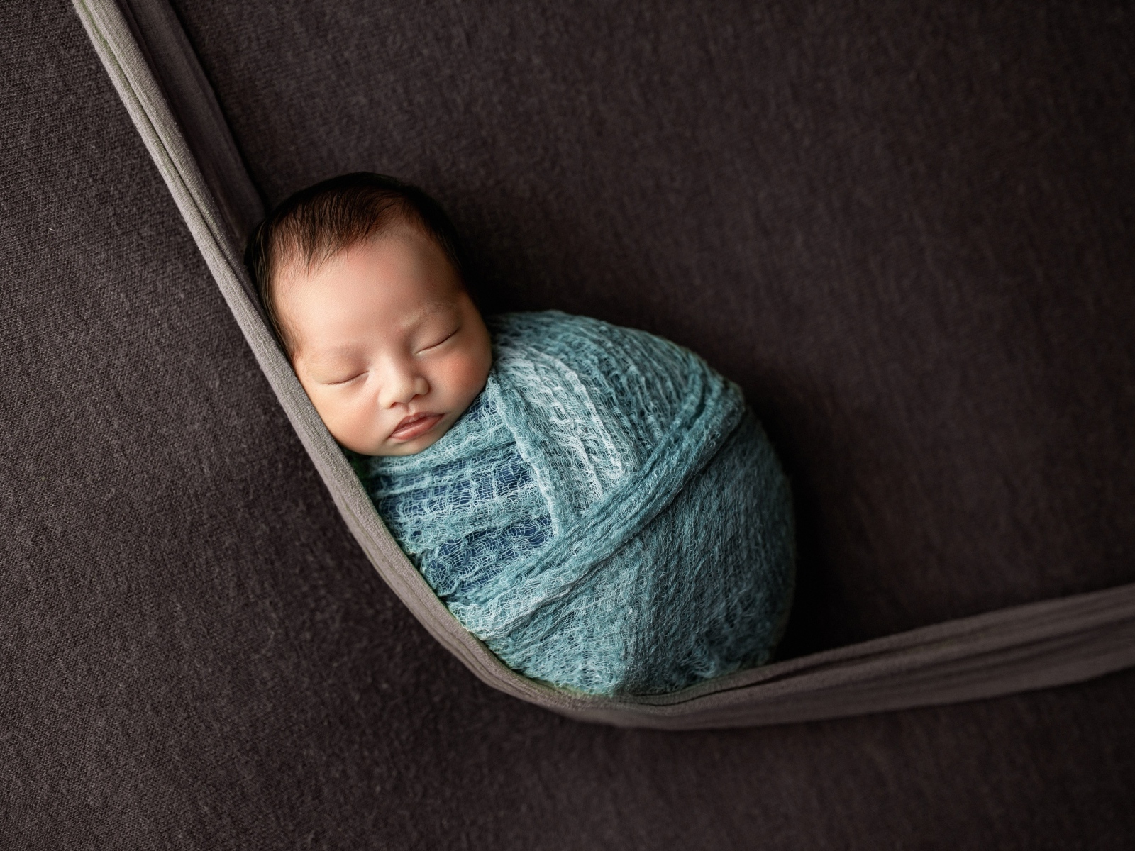 Маленький спящий ребенок завернут в покрывало