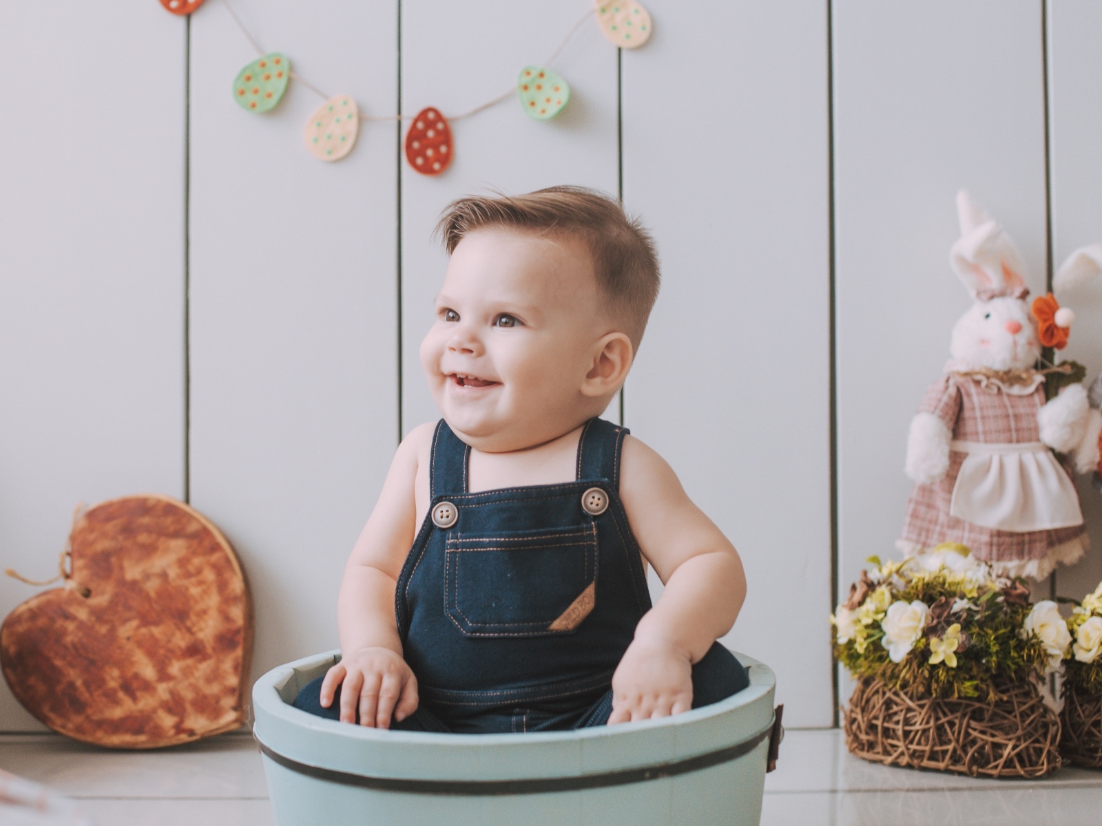 Улыбающийся ребенок сидит в ведре 