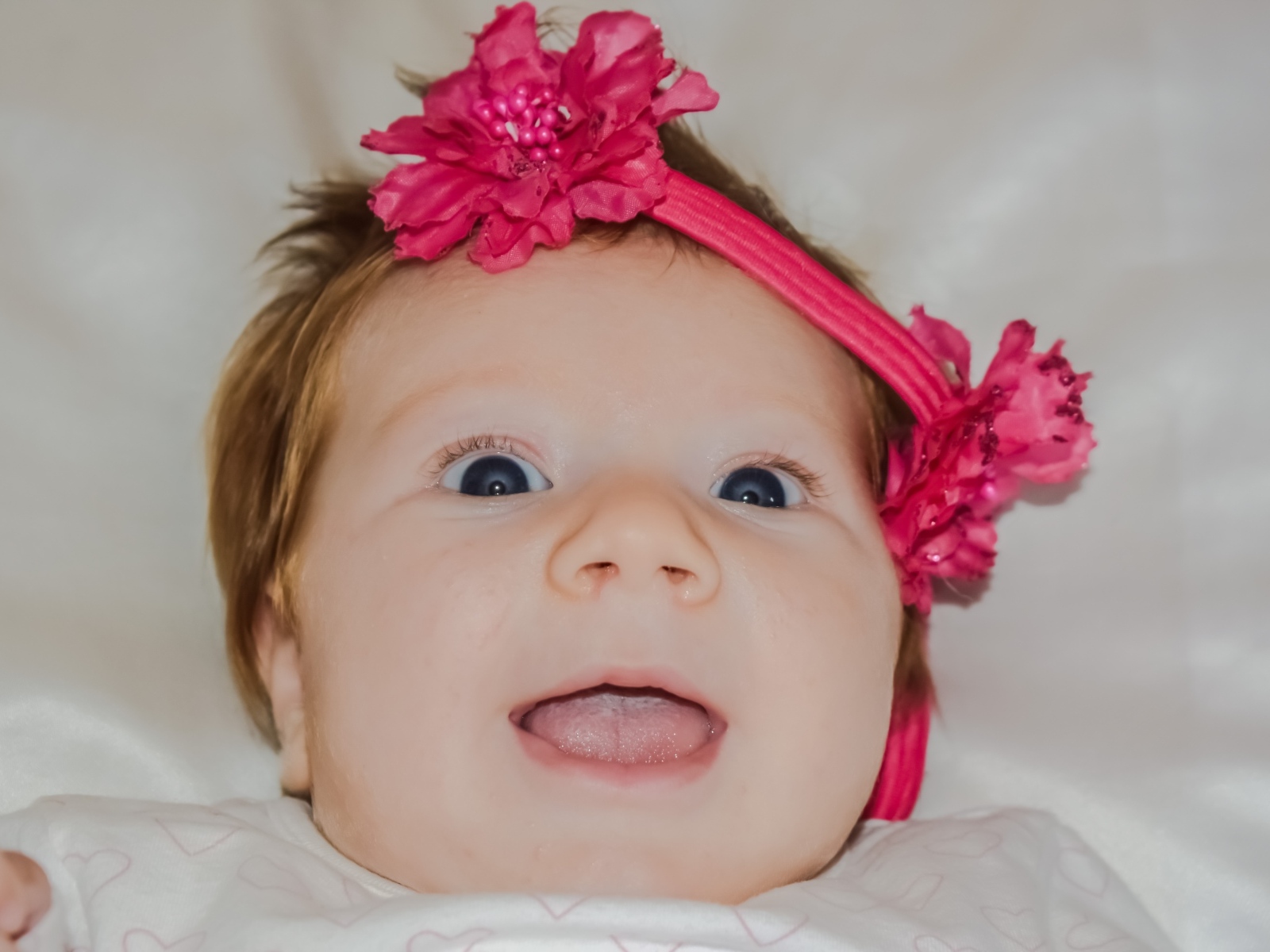 Улыбающаяся маленькая девочка с цветком на голове