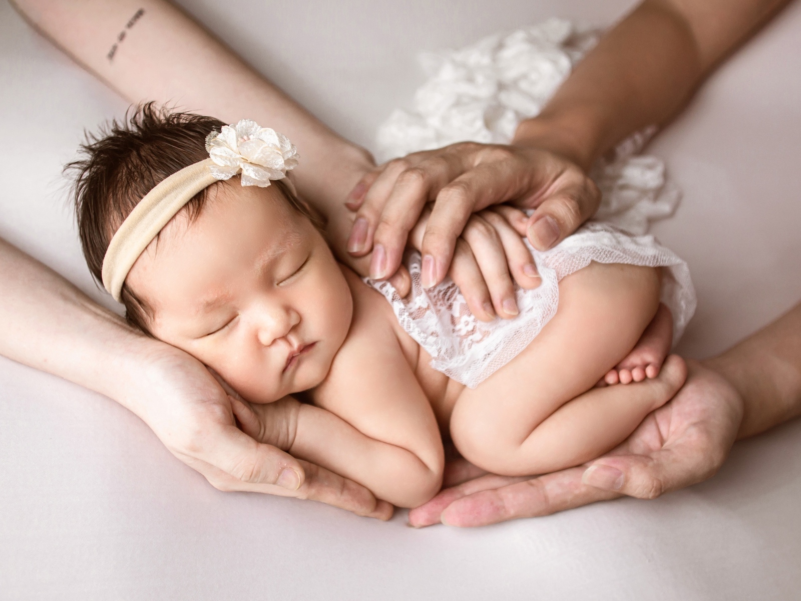 Руки родителей оберегают спящего малыша