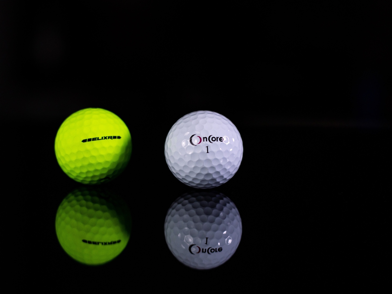 Два мяча для гольфа на черном фоне
