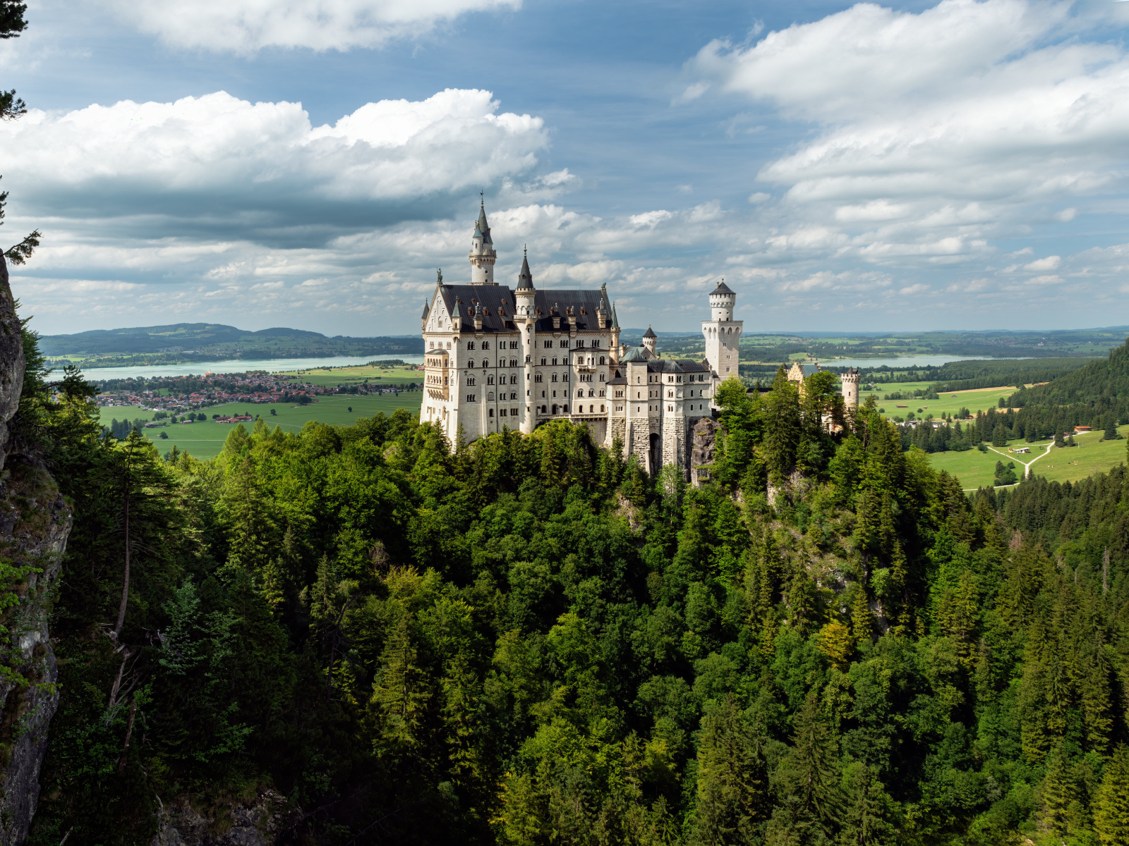Замок Нойшванштайн в густых зарослях деревьев, Германия