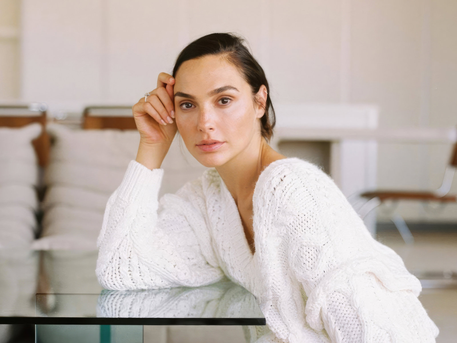 Актриса Галь Гадот в белом свитере за столом