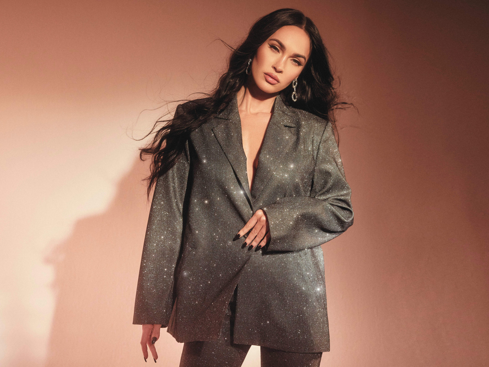 Актриса Меган Фокс в ярком костюме у стены