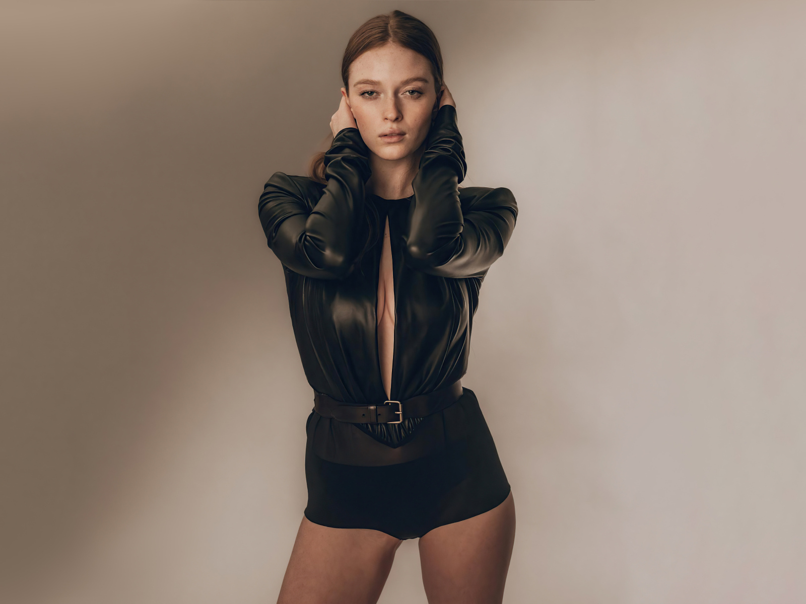 Девушка Ларсен Томпсон в черном костюме у стены