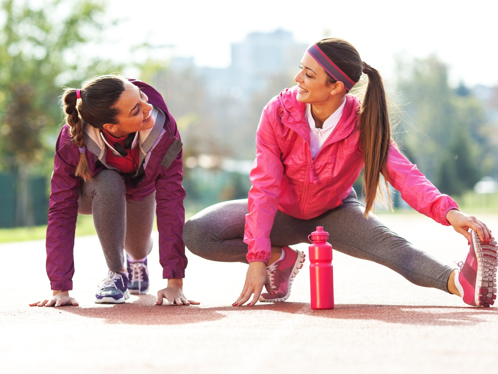 Две спортивные девушки делают растяжку 