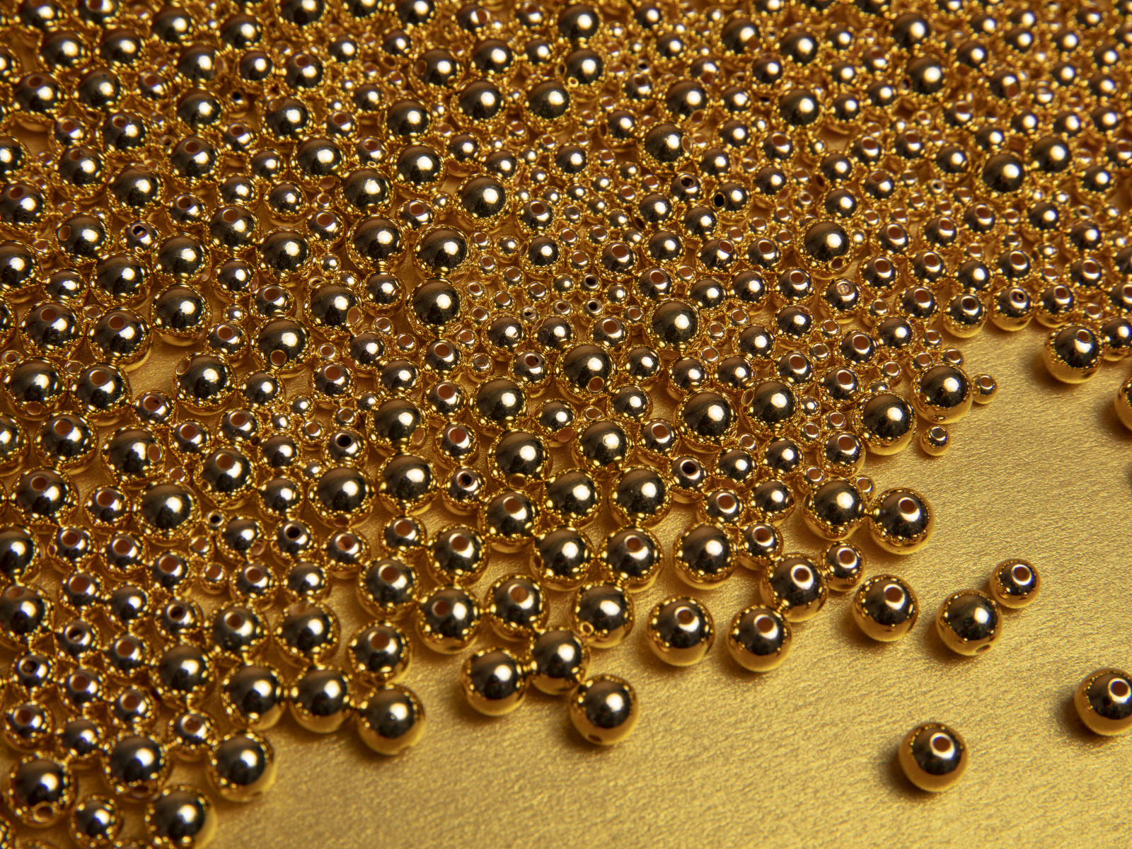 Много золотых бусин на желтом фоне