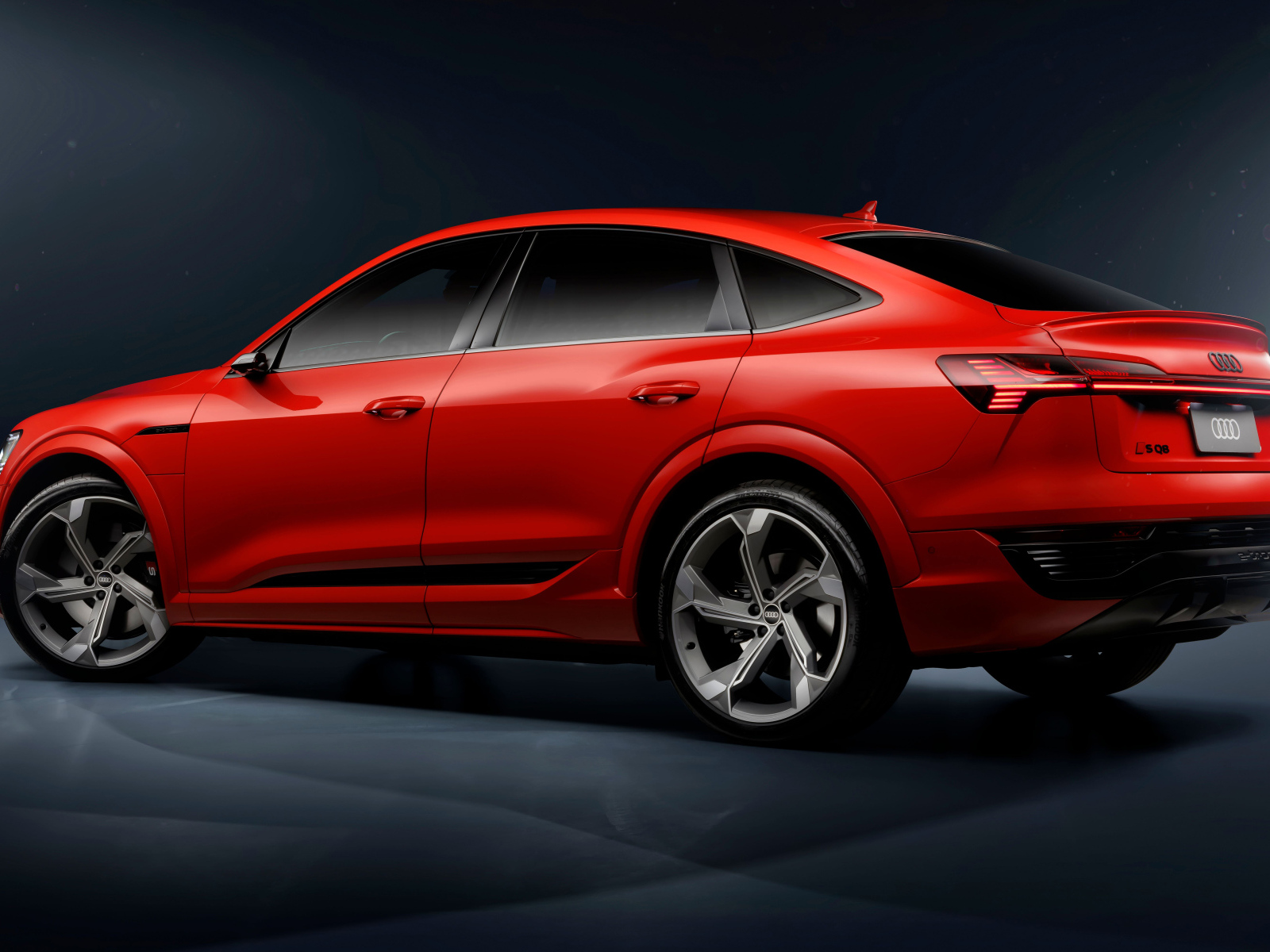 Вид сзади на красный автомобиль Audi SQ8 Sportback E-Tron Quattro 2024 года