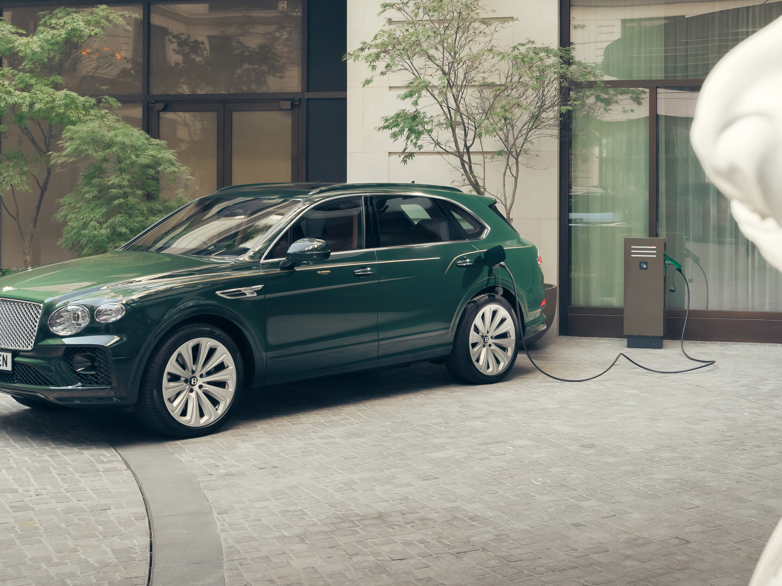 Зеленый автомобиль Bentley Bentayga Hybrid Peninsula London 2024 года