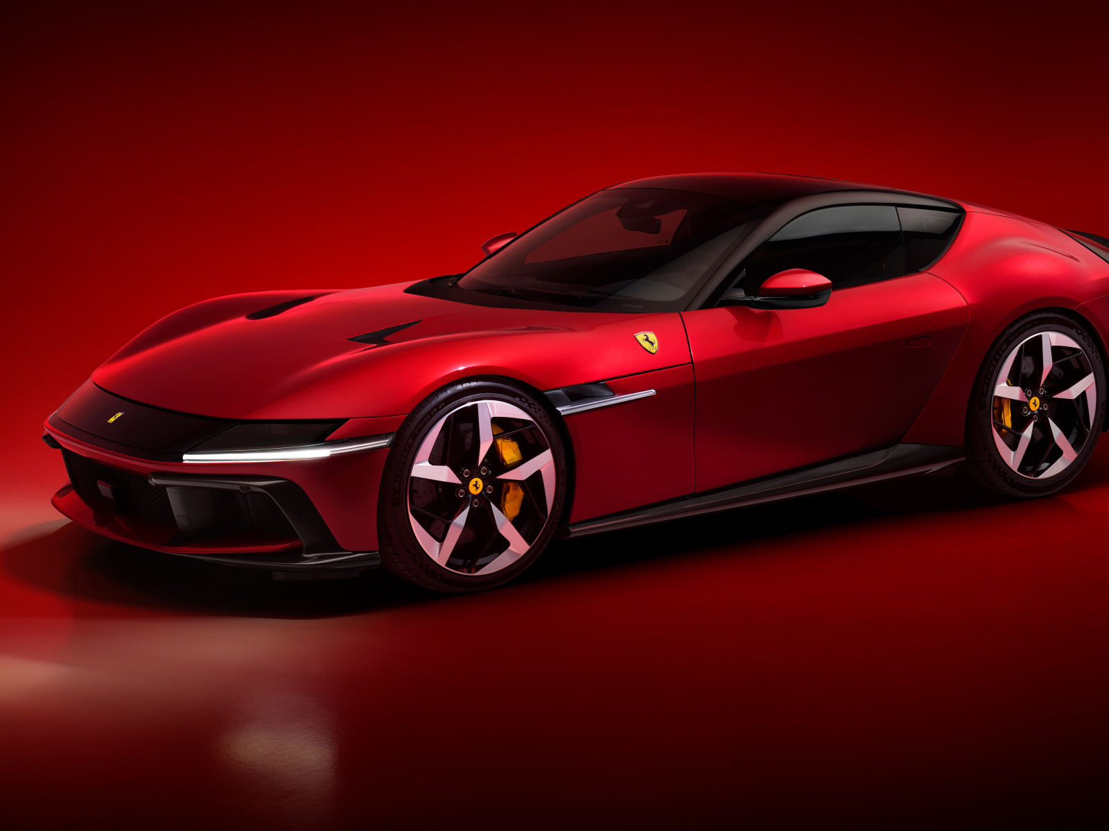 Автомобиль Ferrari 12Cilindri 2024 года на красном фоне