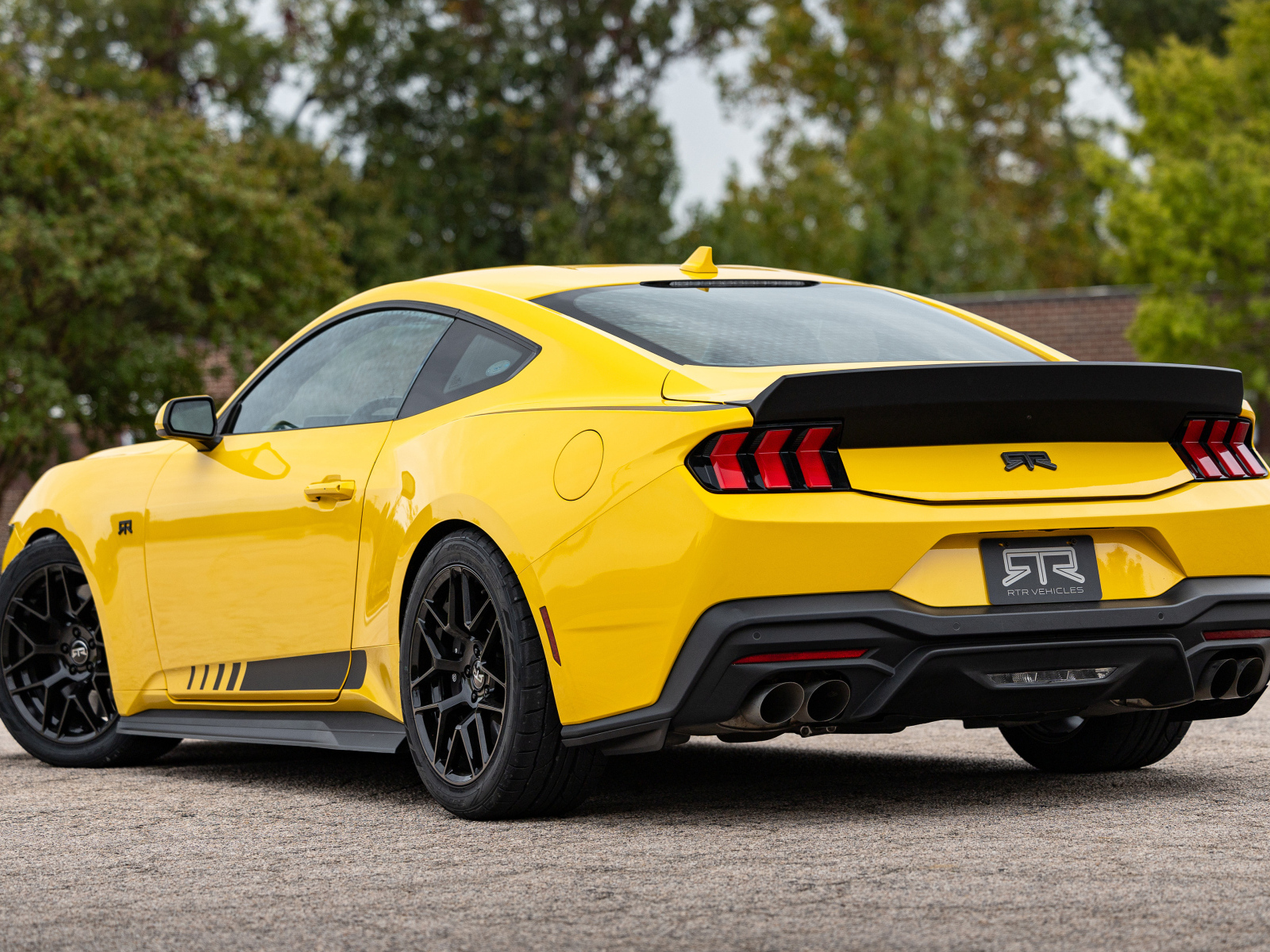 Вид сзади на желтый автомобиль RTR Ford Mustang S650 2024 года