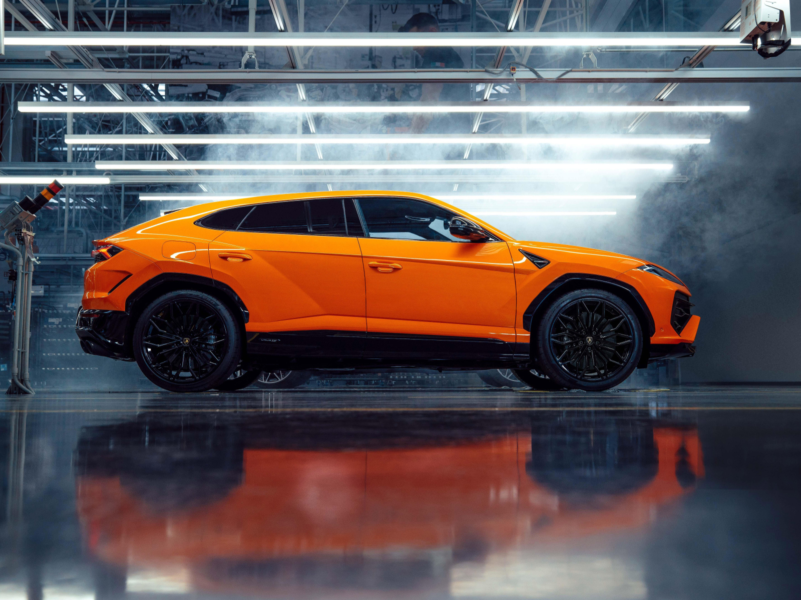 Оранжевый автомобиль Lamborghini Urus SE Plug-In Hybrid Super SUV вид сбоку