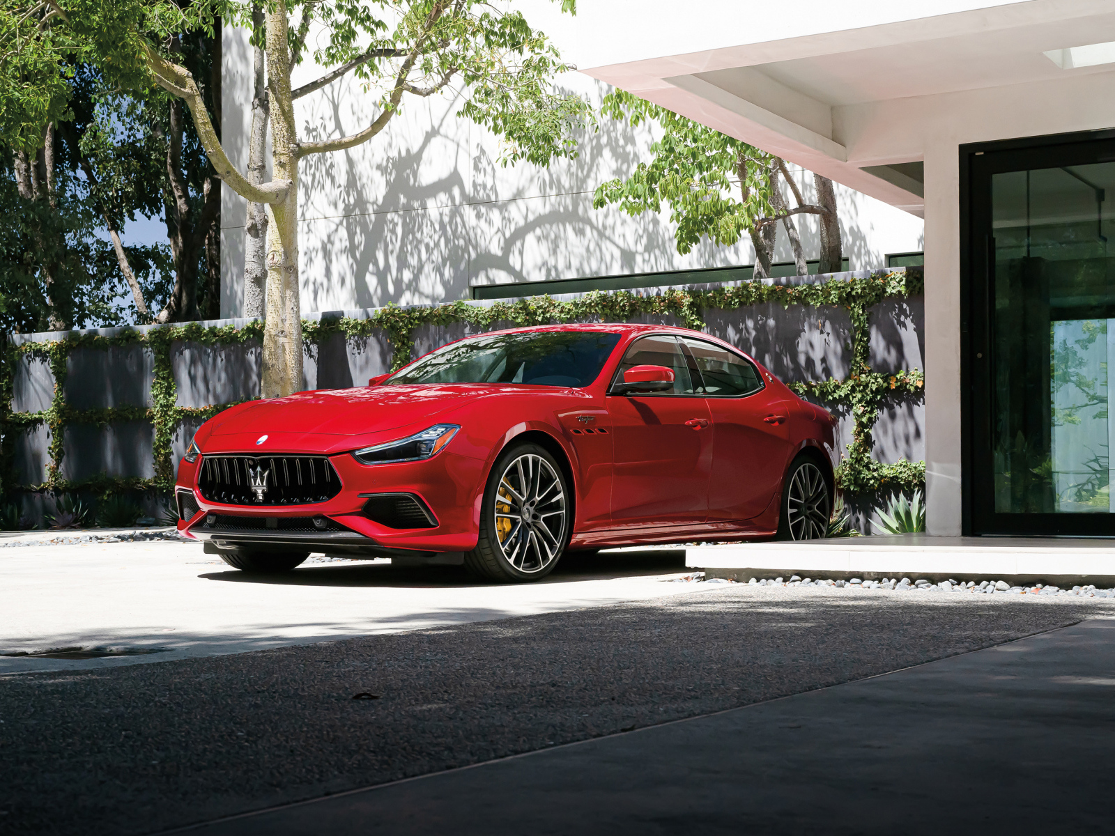 Красный автомобиль Maserati Ghibli Trofeo у дома