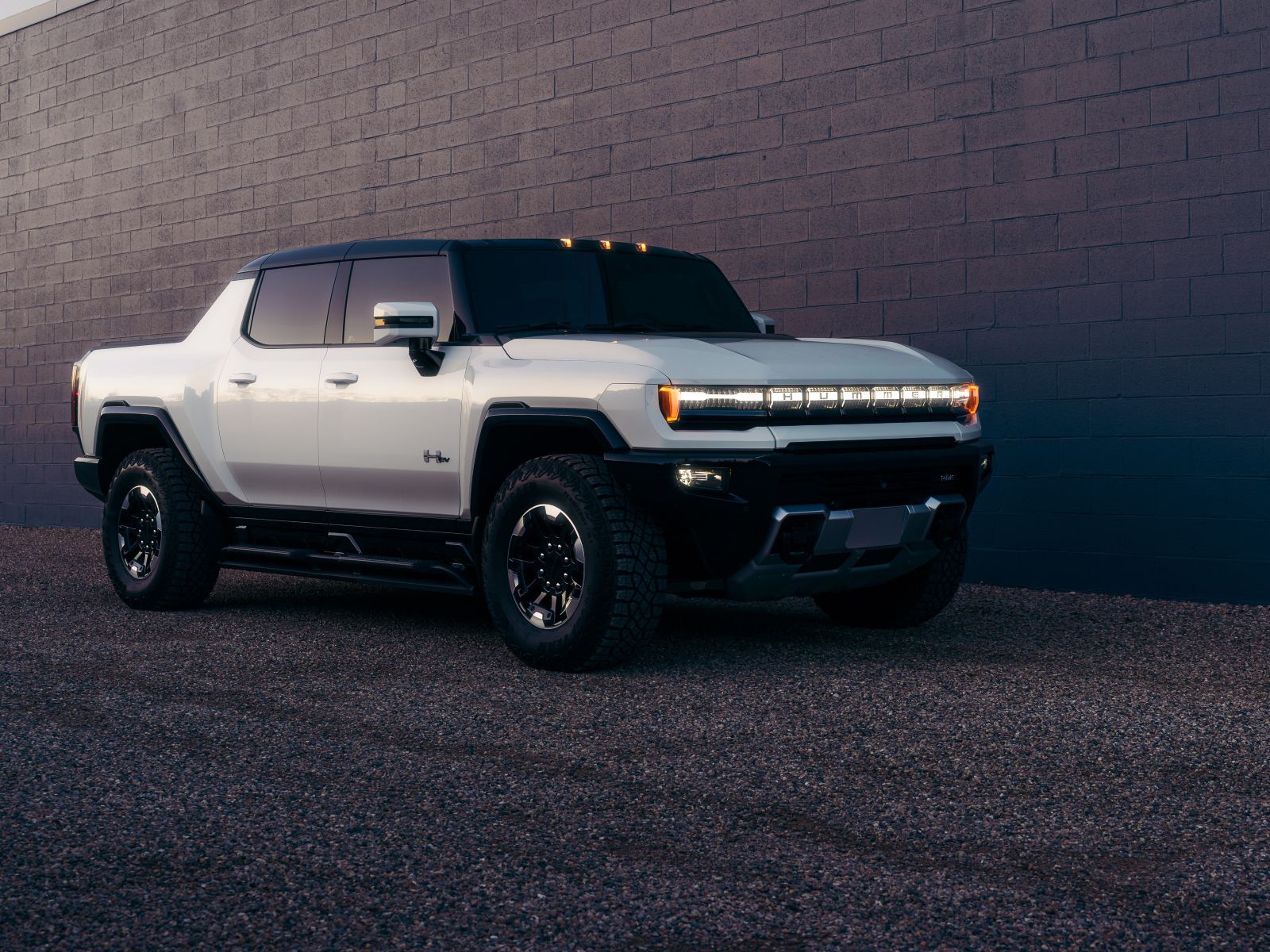 Большой стильный Hummer EV  у стены
