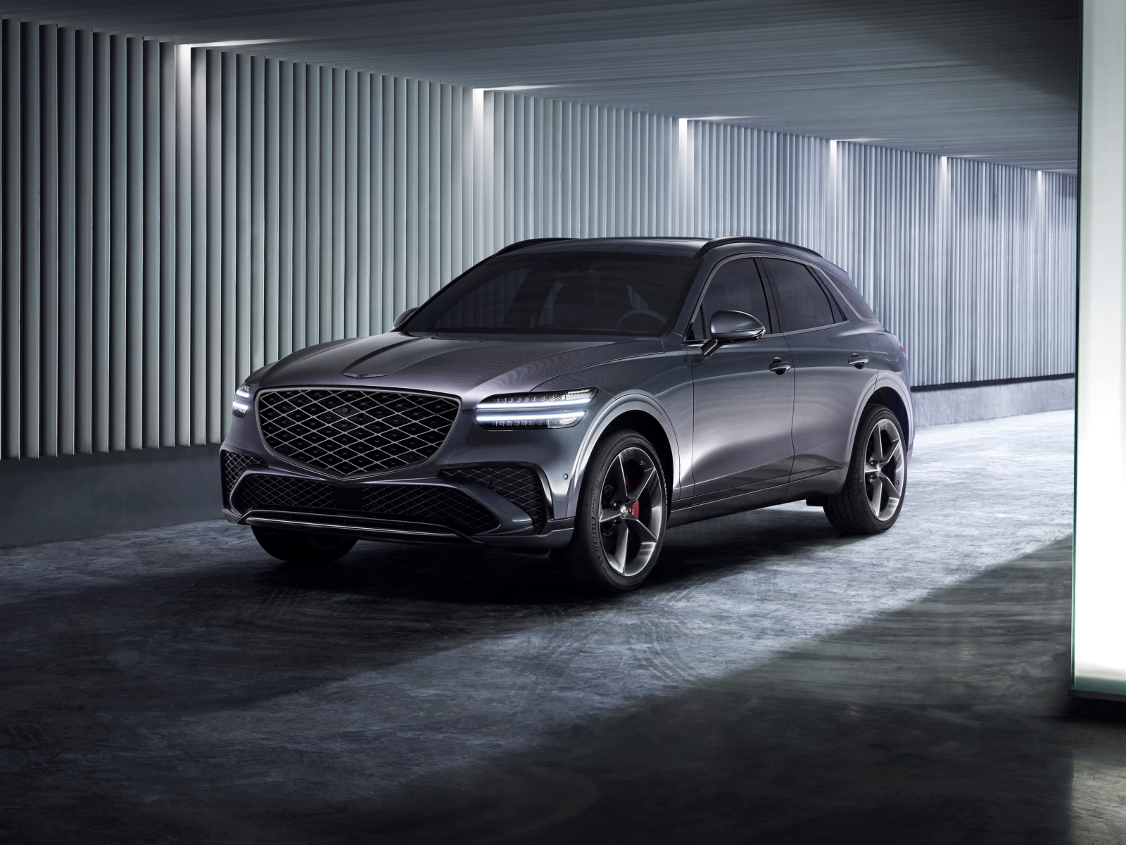 Серебристый автомобиль Genesis GV70 Sport 2024 года