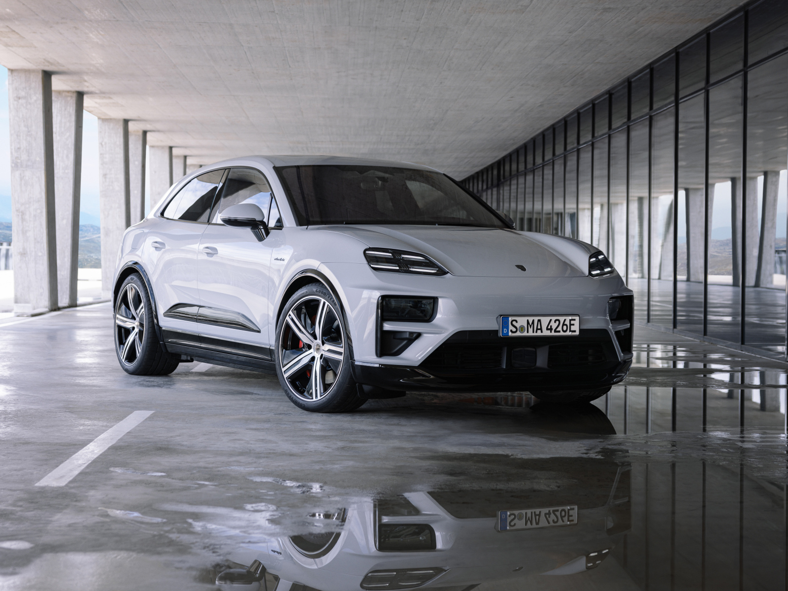 Большой Porsche Macan Turbo 2024 года у здания