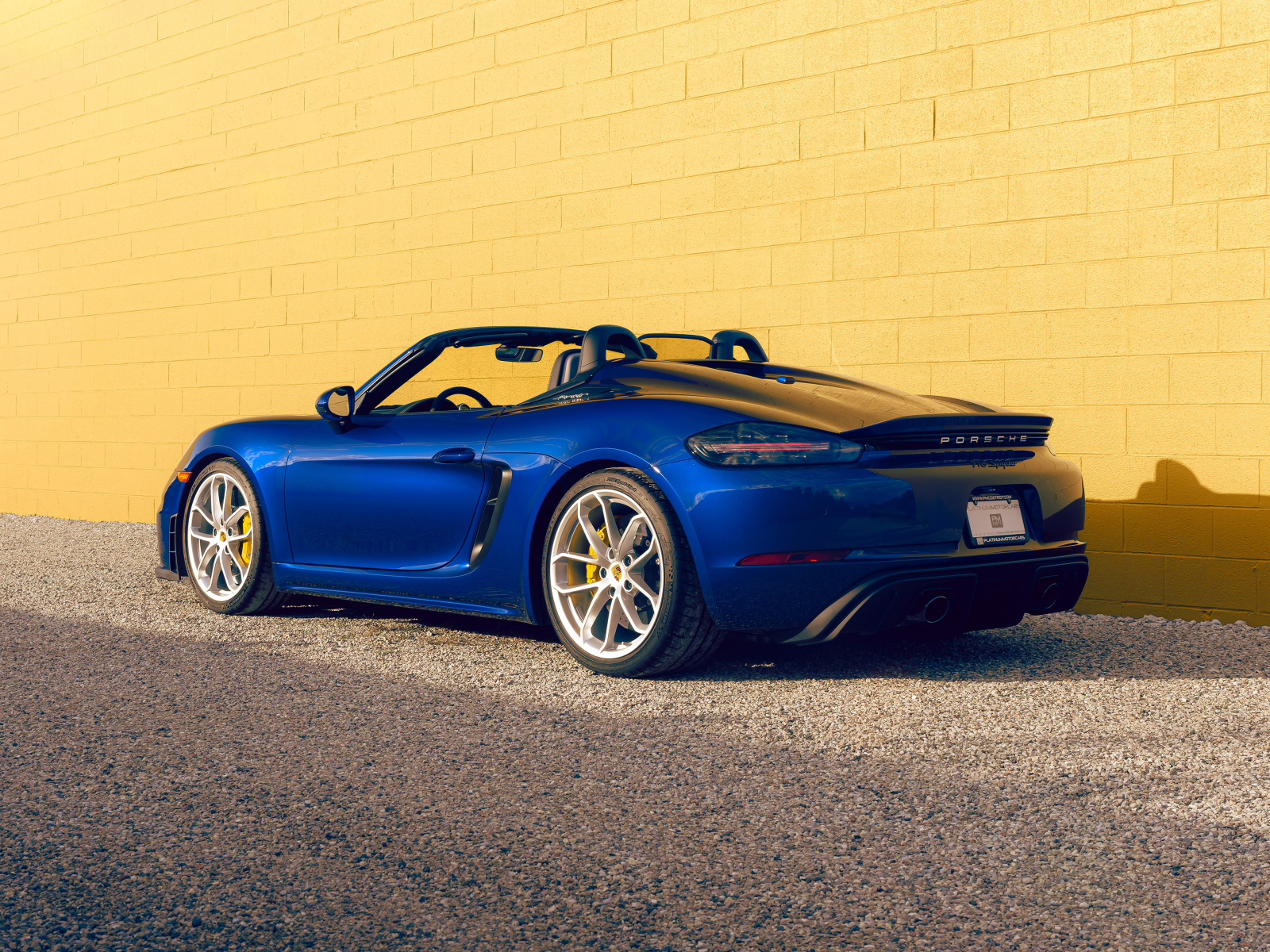 Вид сзади на синий автомобиль Porsche 718 Spyder