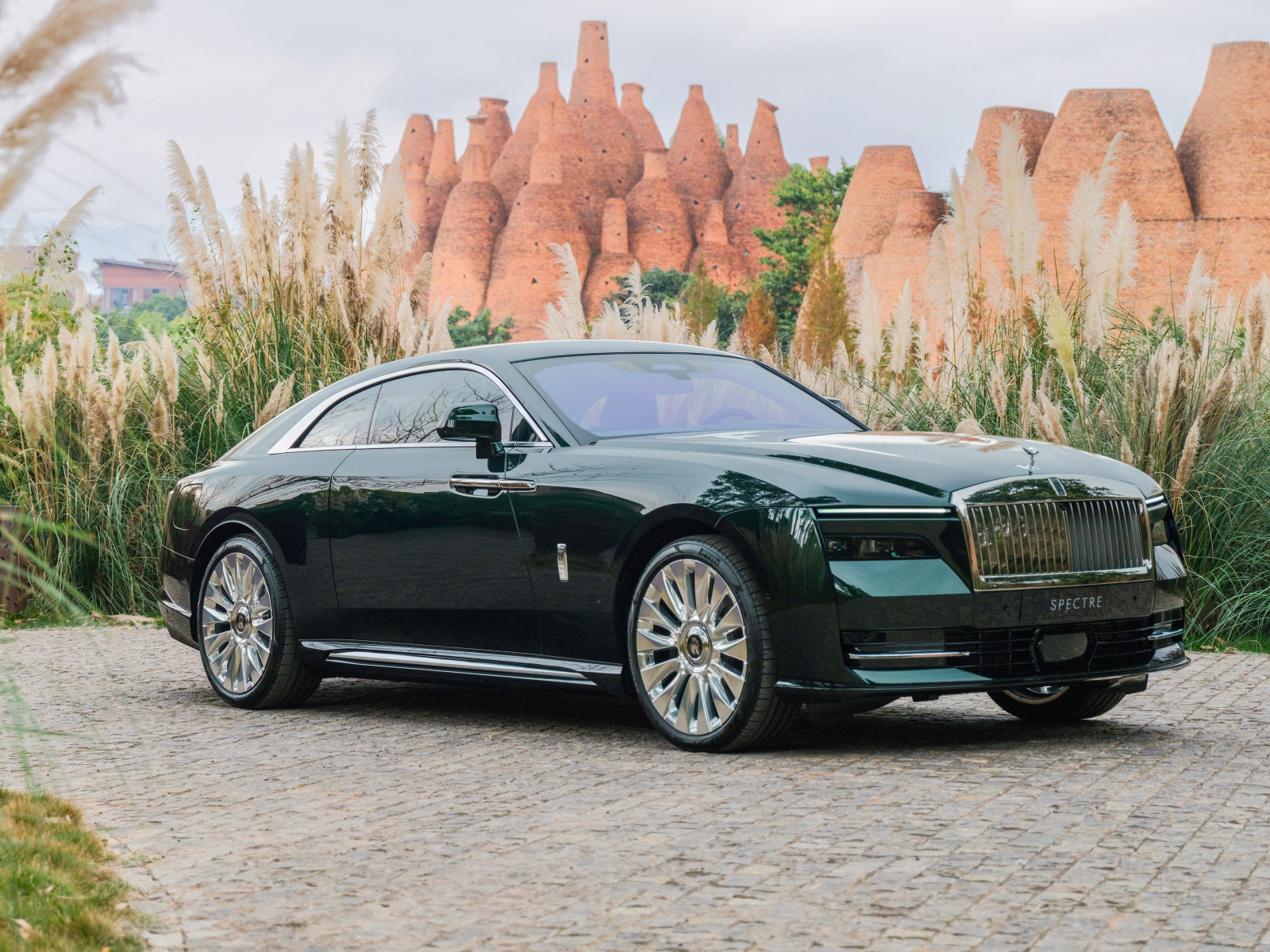 Дорогой зеленый автомобиль Rolls-Royce Spectre