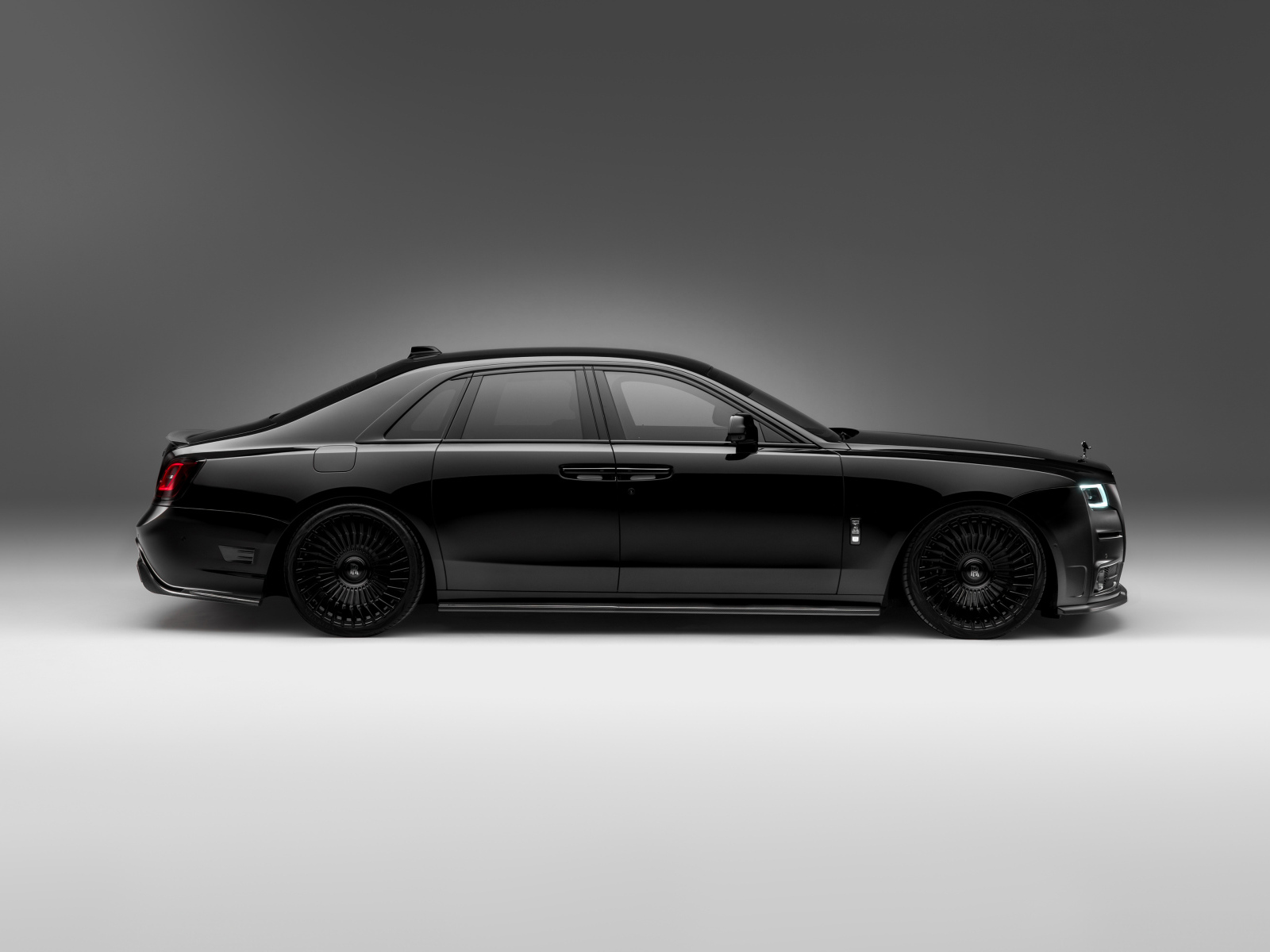 Вид сбоку на черный автомобиль Rolls-Royce Ghost