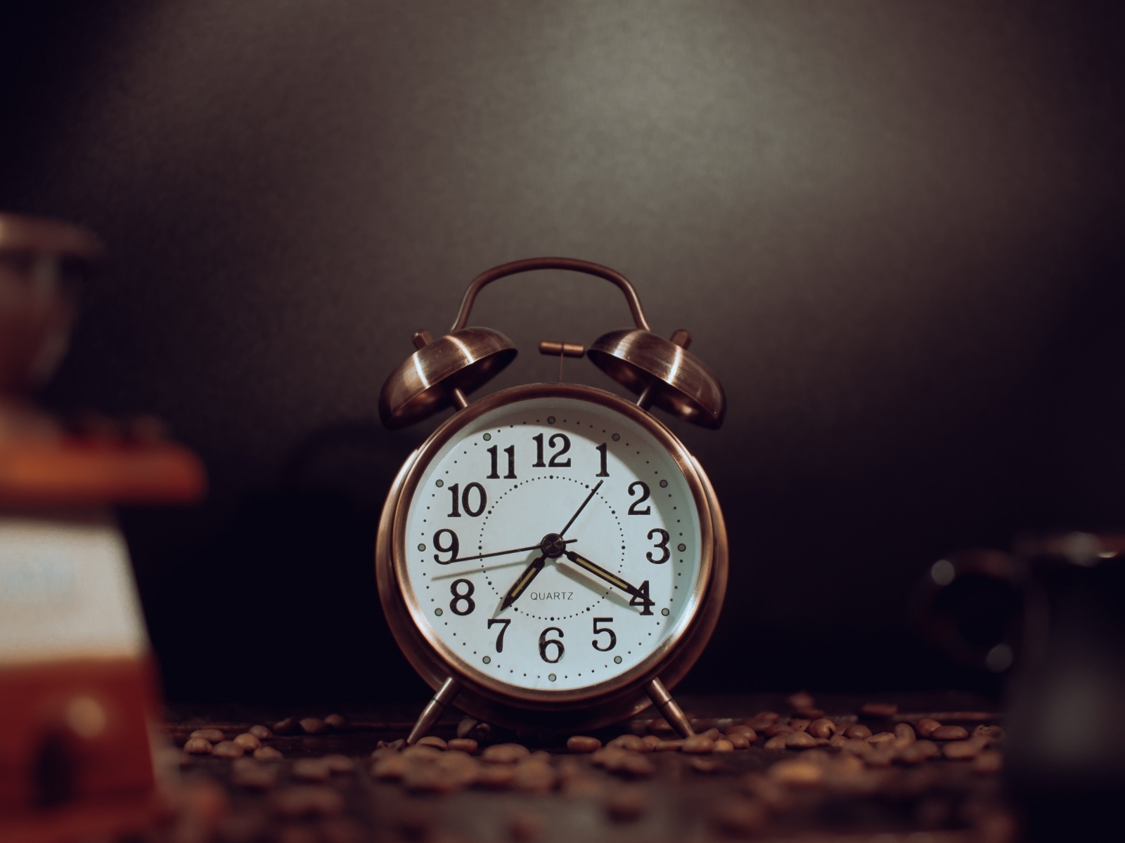 Будильник на столе с зернами кофе