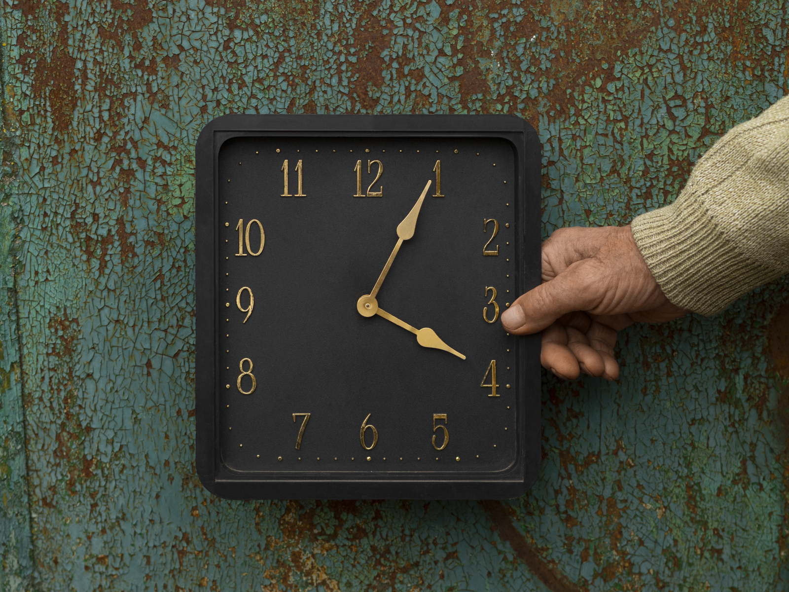 Черные квадратные часы на старой стене
