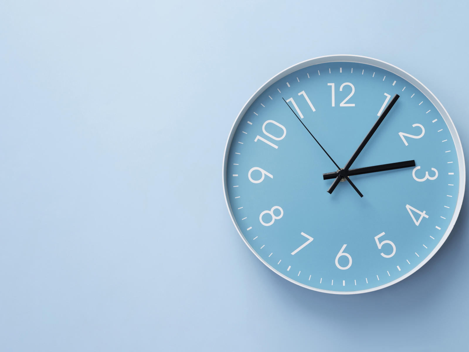 Круглые часы на голубом фоне крупным планом