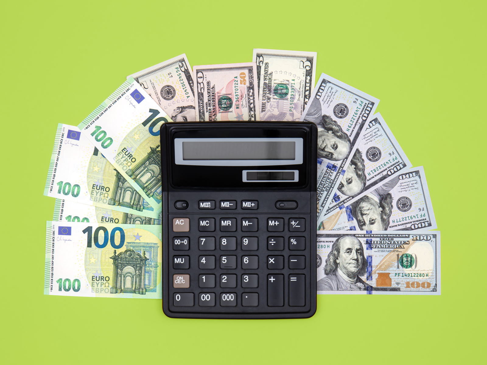 Калькулятор и доллары на зеленом фоне