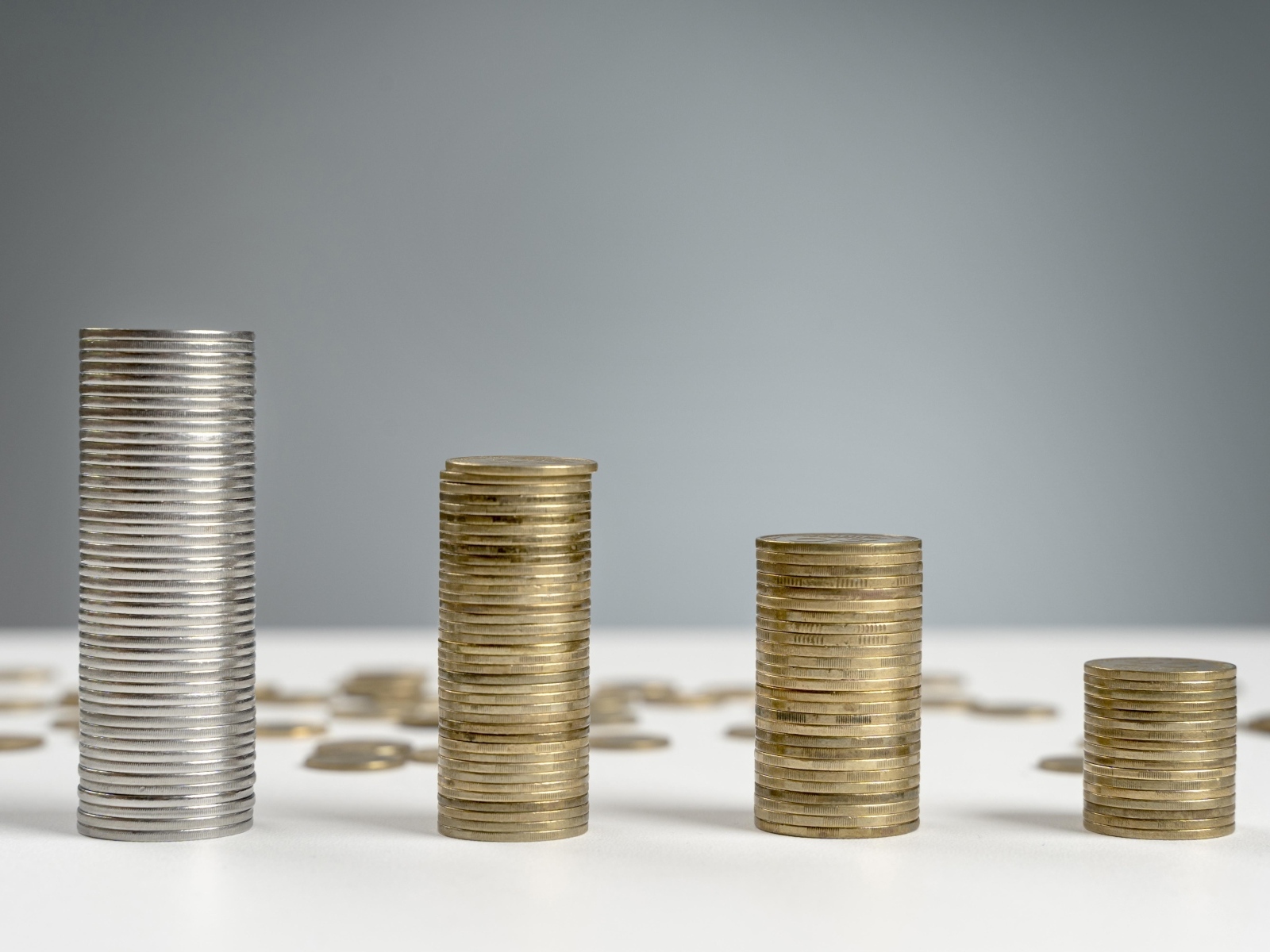 Стопки монет на сером фоне на столе